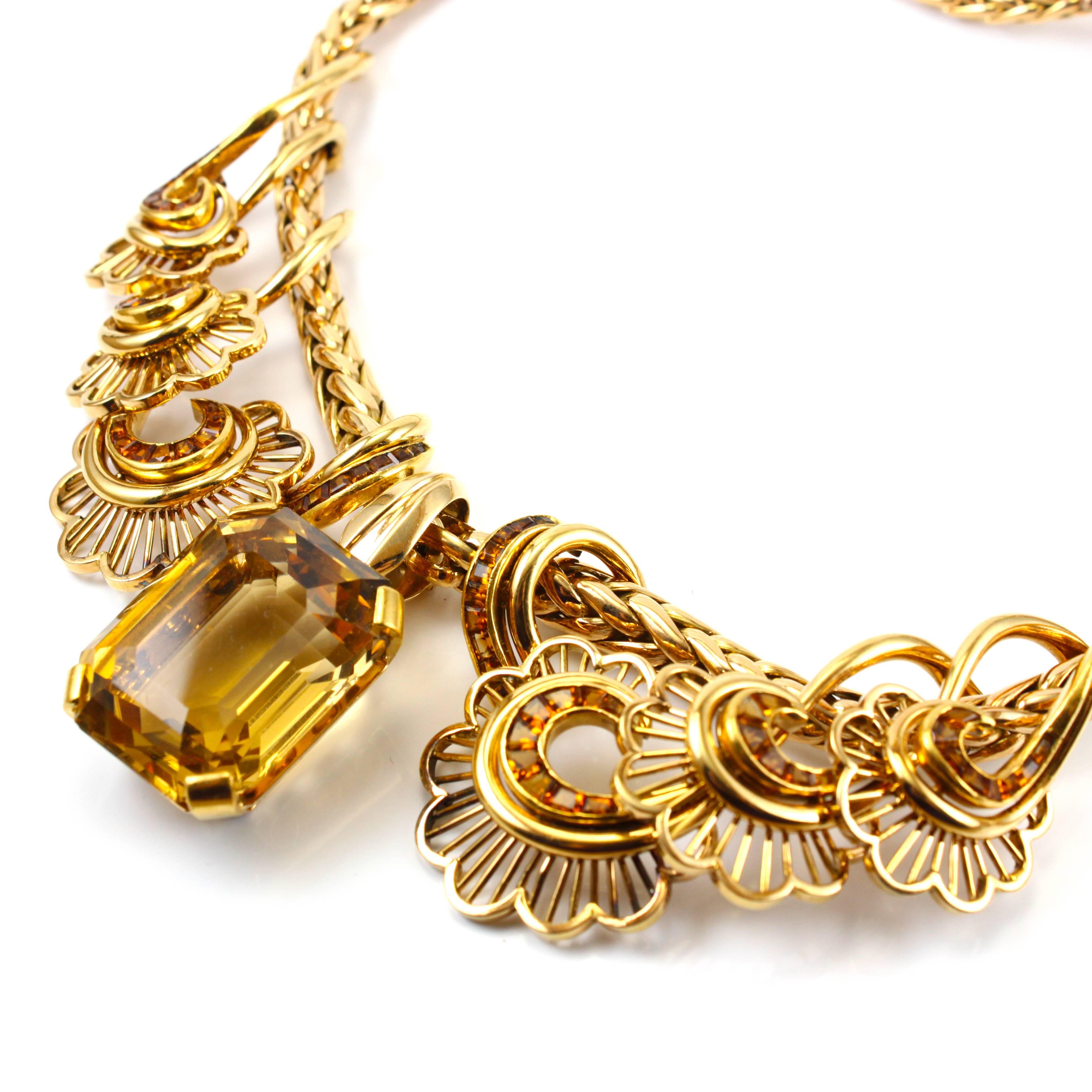Beautiful retro necklace in 18k yellow gold, France, 1940s. The centre stone is a big emerald cut citrine, weighing circa 60 carats, it can also be detached and worn as a pendant. The floral design on either side of the centre stone is accentuated