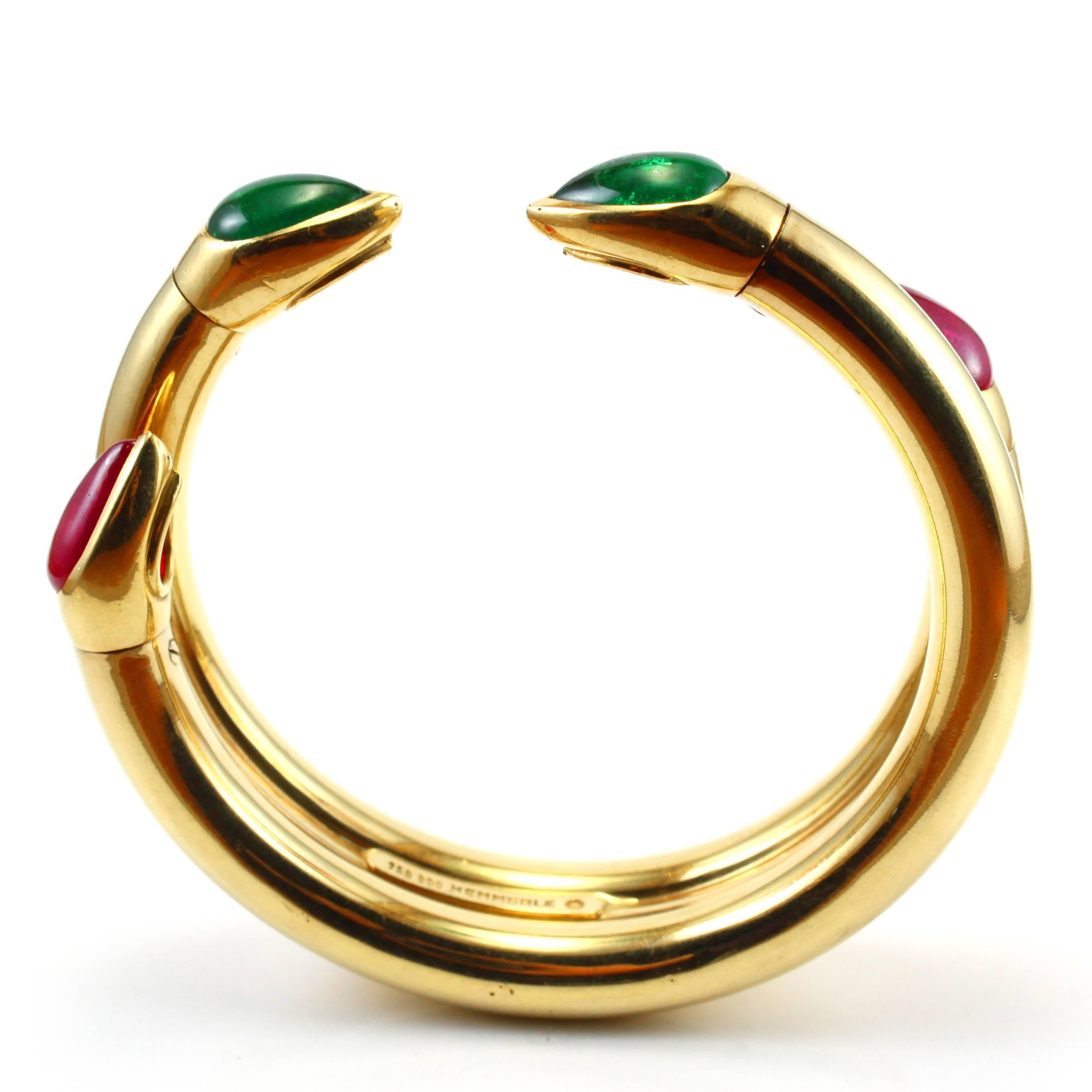 An important ruby and emerald cuff bangle in 18k yellow gold, by Hemmerle, late 20th Century. The two fine red ruby drops are natural (not-heated) and weigh circa 8 carats together and the two intense green emerald drops weigh circa 5 carats