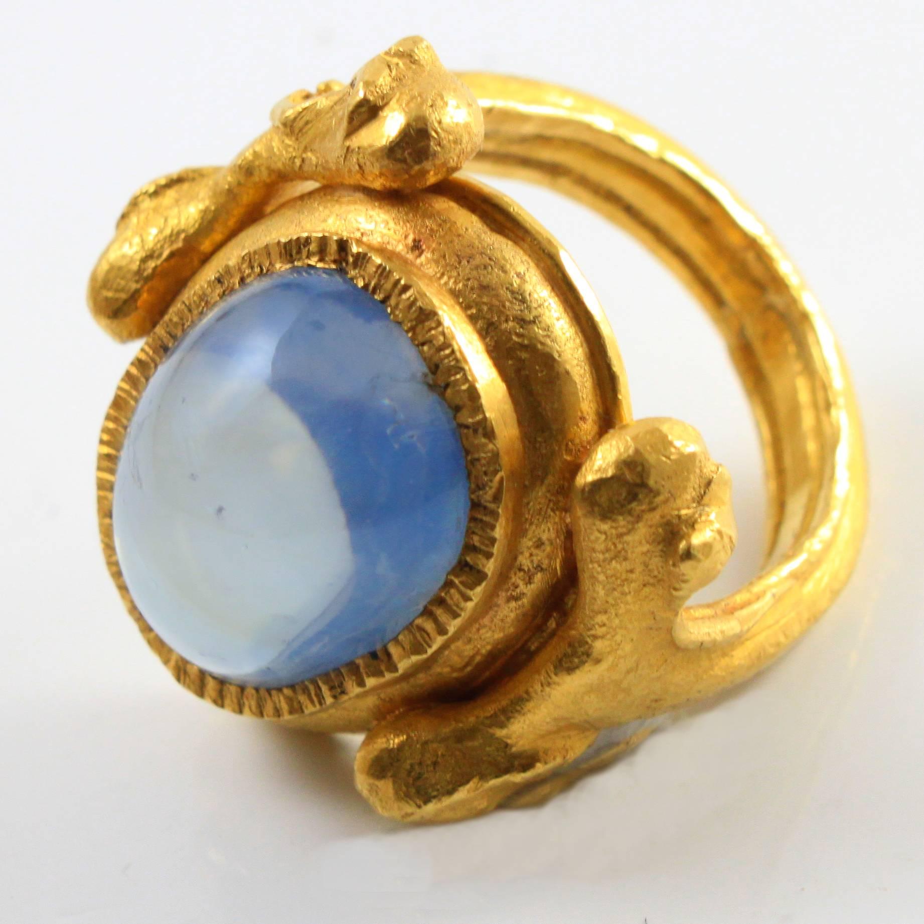 An abstract and massive 22k gold and sapphire ring by Wolfgang Skoluda.

The ring is mounted with a large natural sapphire cabochon of circa 30 carats showing a velvety blue colour, surrounded by high carat and massive gold in a greek artisan