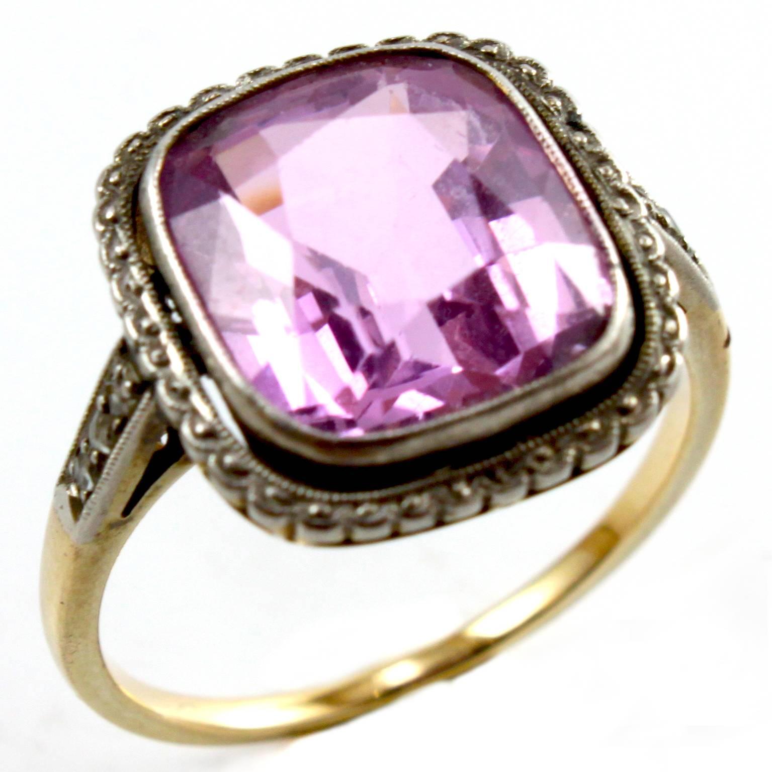 A graceful Edwardian ring with a central old mine Pink Topaz cushion, weighing circa 6 carats, and flanked by small rosecut diamonds - the Pink Topaz has a very lovely hue. 