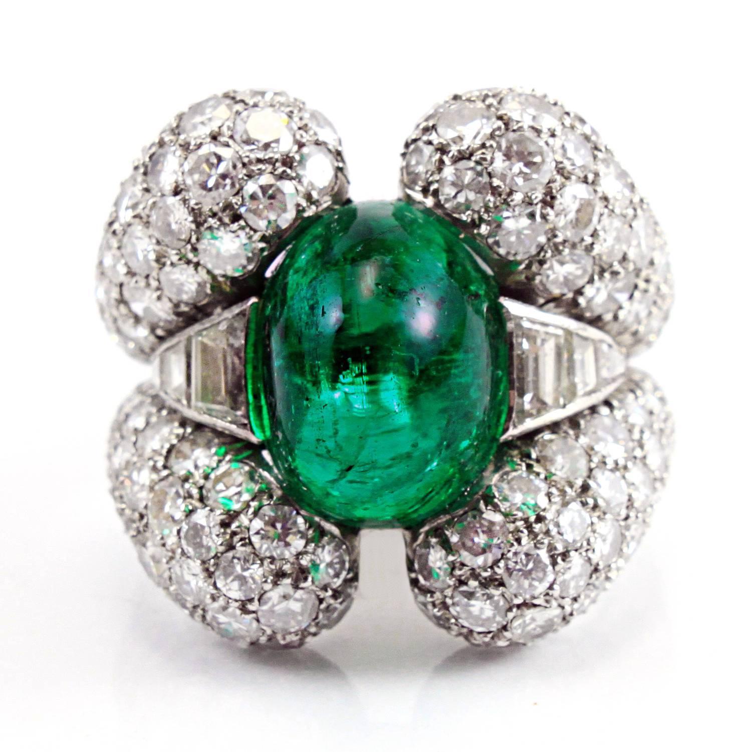 A very chic emerald and diamond ring from the 1940s, centring an important old-mine Colombian emerald of ca. 9 carats and ca. 6 carats of diamonds in four clusters around it. The ring is made in platinum and is most probably French.
