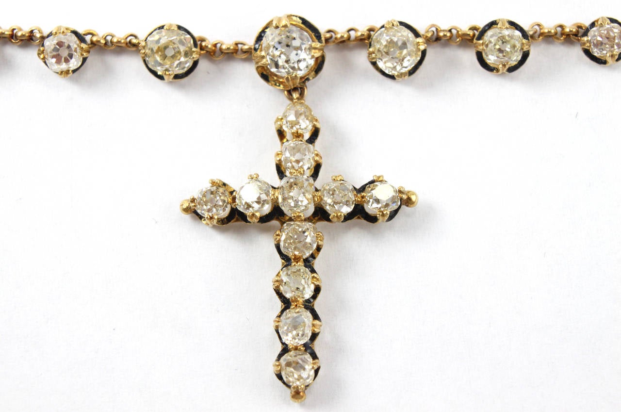 A very special cross pendant necklace, studded with old-cut diamonds of ca. 8-9 carats. Each diamond is beautifully mounted in a ring of black enamelled gold.