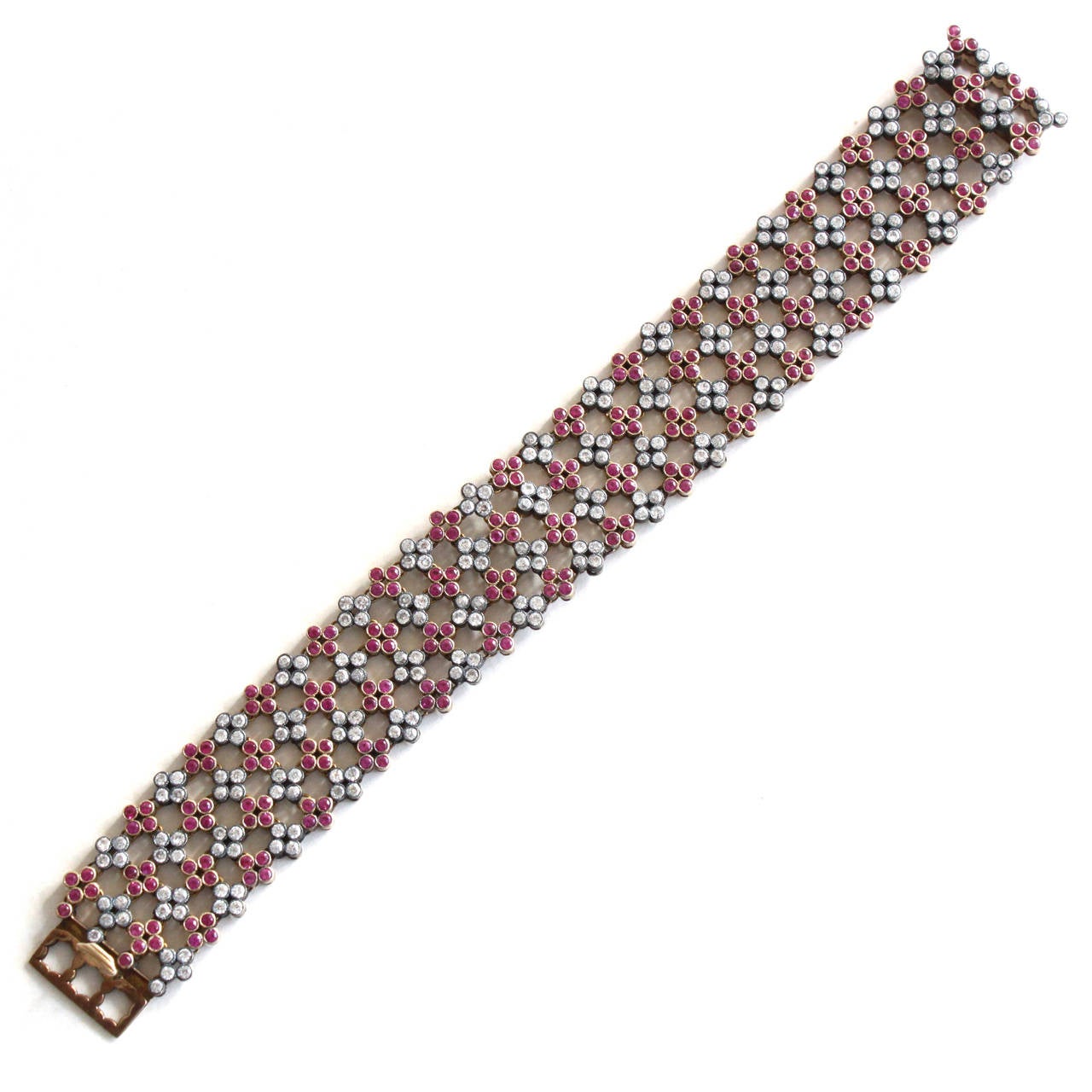 A very chic and unusual cluster bracelet, alternating with fine rubies and diamonds in a unique floral quatrefoils design. 
This bracelet would beautifully complement a lace dress or a wedding gown.

The diamonds and rubies weigh ca. 3.5 carats
