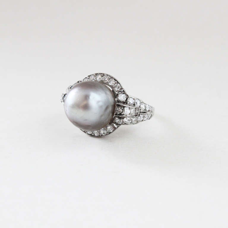 This is a pretty Art Deco ring from the 1920s, mounted with a rare grey natural saltwater bouton pearl (certified) of 41 grains and surrounded by diamonds. Ring size 5-1/2.