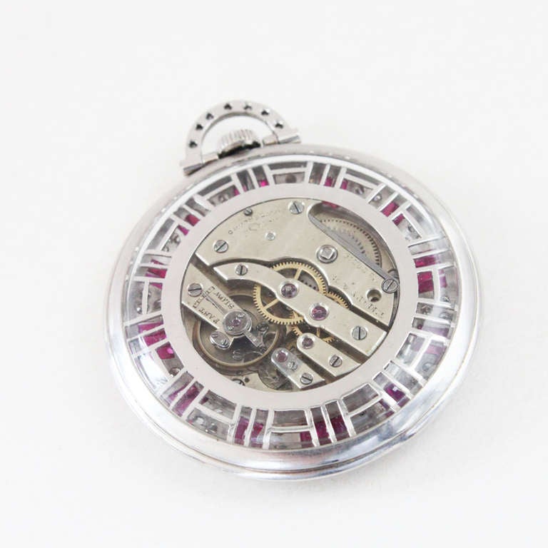 Tiffany & Co. Art Deco platinum pocket watch from the 1920s. Set with natural rubies (approx. 3 carats) and diamonds (approx. 3 carats) along the bezel and bow. Attached to a 14k gold chain. Signed and numbered.