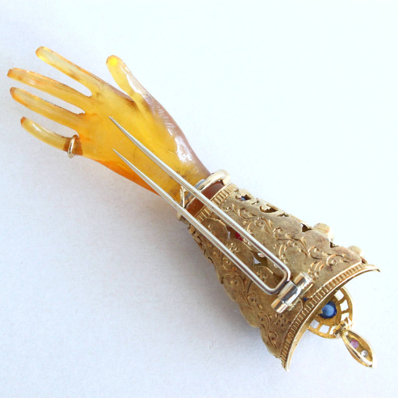 A beautiful pin/pedant by Nardi, depicting the Venetian symbol of a hand.

The hand is carved very realistically out of blond tortoise shell and is decorated with a small diamond ring on the pinky finger; a movable ruby and diamond bracelet; and a