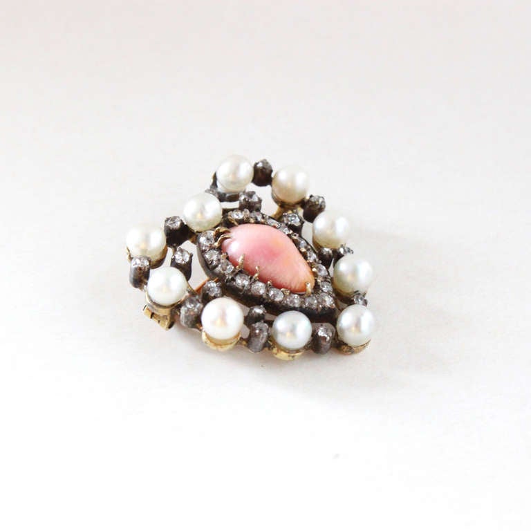 An unusual Antique Victorian brooch from the 1890s in the form of a heart, centering a rare drop shaped conch pearl with the much sought after and beautiful flame structure and lustre, surrounded by several natural pearls and diamonds.

As the