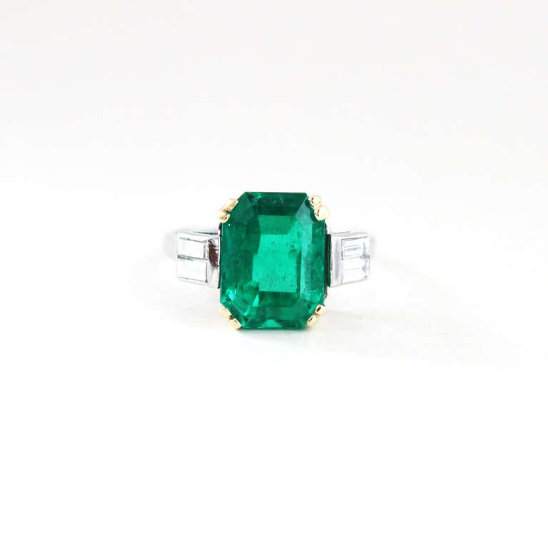 A lustrous Colombian Emerald and Diamond Ring. The emerald weighs  4.46 carats and is of very gem quality. It is of Colombian origin, with beautiful colour and crystal. Surrounded by baguette diamonds of circa 0.3 carats. French hallmarks. 

Ring
