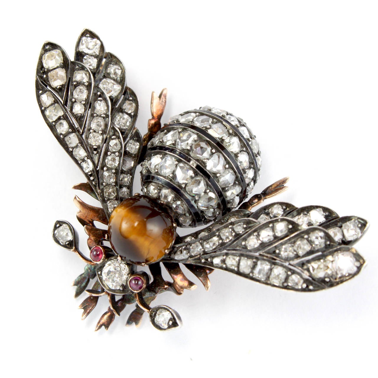 A beautiful jewellery broach in the form of a bumble bee, French 1880s.
The thorax is artistically studded with a tigereye, the eyes with two ruby cabochons and the rest of the body with old cut and rose cut diamonds. The center diamond weighs