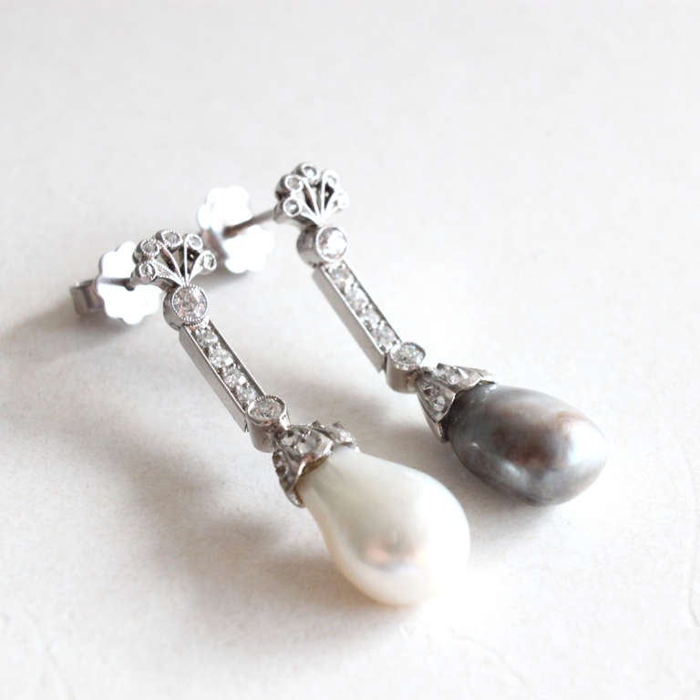 Very elegant Natural Pearl Earrings in the combination of one grey pearl (5.38 carats) and one white pearl (5.26 carats). Both Pearls are certified as Natural Saltwater Pearls by DSEF, the German Gem Lab. 

Natural saltwater pearls are organic