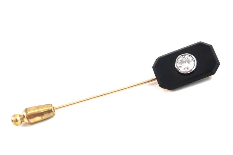 This Art Deco tie pin is very sleek and elegant. The center diamond weighs circa 0.6 carats and is of H-I colour and VS clarity. The diamond is surrounded by black onyx.