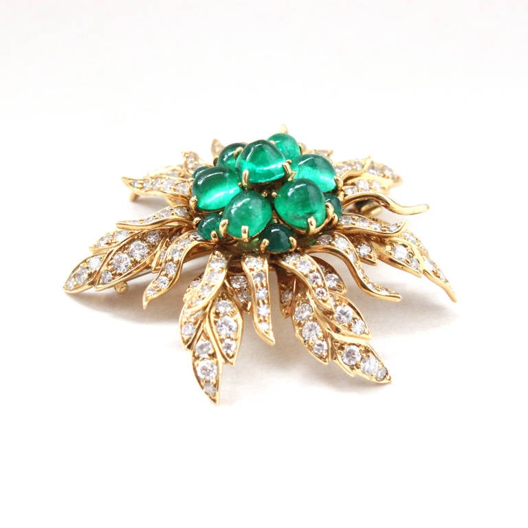 A yellow gold emerald cabochon and diamond flower brooch by Cartier, signed and numbered. Cartier has crafted this piece on three parts, which are moveable and fixated through a screw at the back. The first two parts are the flower petals studded