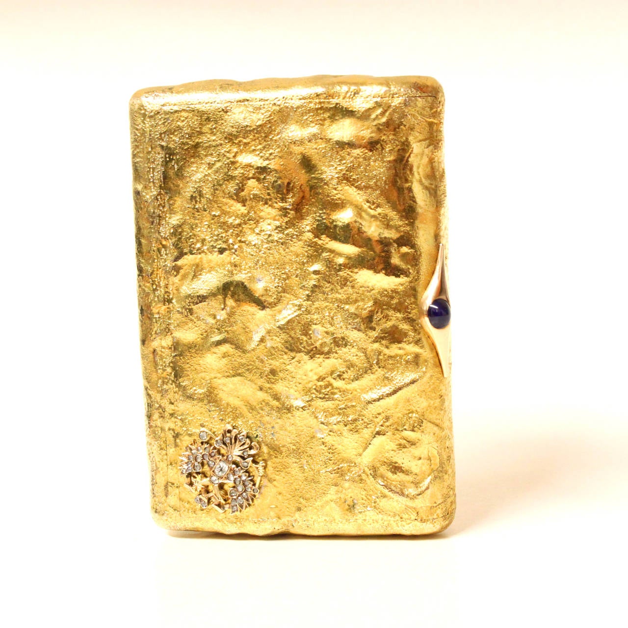 A unique Faberge cigarette box in sand texture like yellow gold, with a sapphire cabochon and a double headed diamond eagle. 
The texture of the box is achieved by the difficult master technique, called Samorodok, where the gold is heated to a