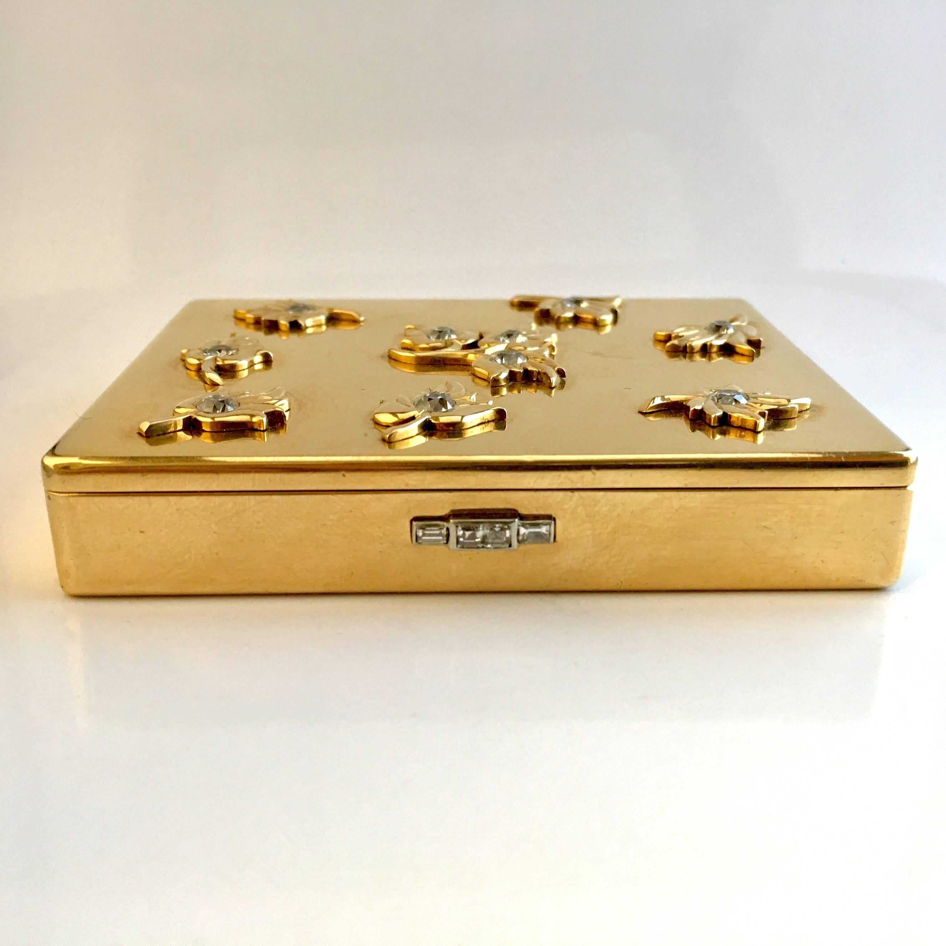 A very charming case by Cartier in 18k yellow gold from the 1940s period. The lid is decorated with 10 golden leafs each set with an old brilliant cut diamond and the clasp is set with square cut diamonds. The total diamond weight is approximately
