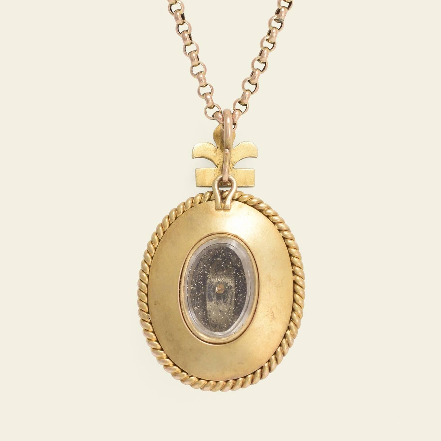 This exquisite mid Victorian locket is modeled in 15k yellow gold with a domed oval centerpiece set with turquoise pavé and a single .06ct old mine cut diamond. The vaulted and gem-studded center surmounts a wide border detailed with immaculate