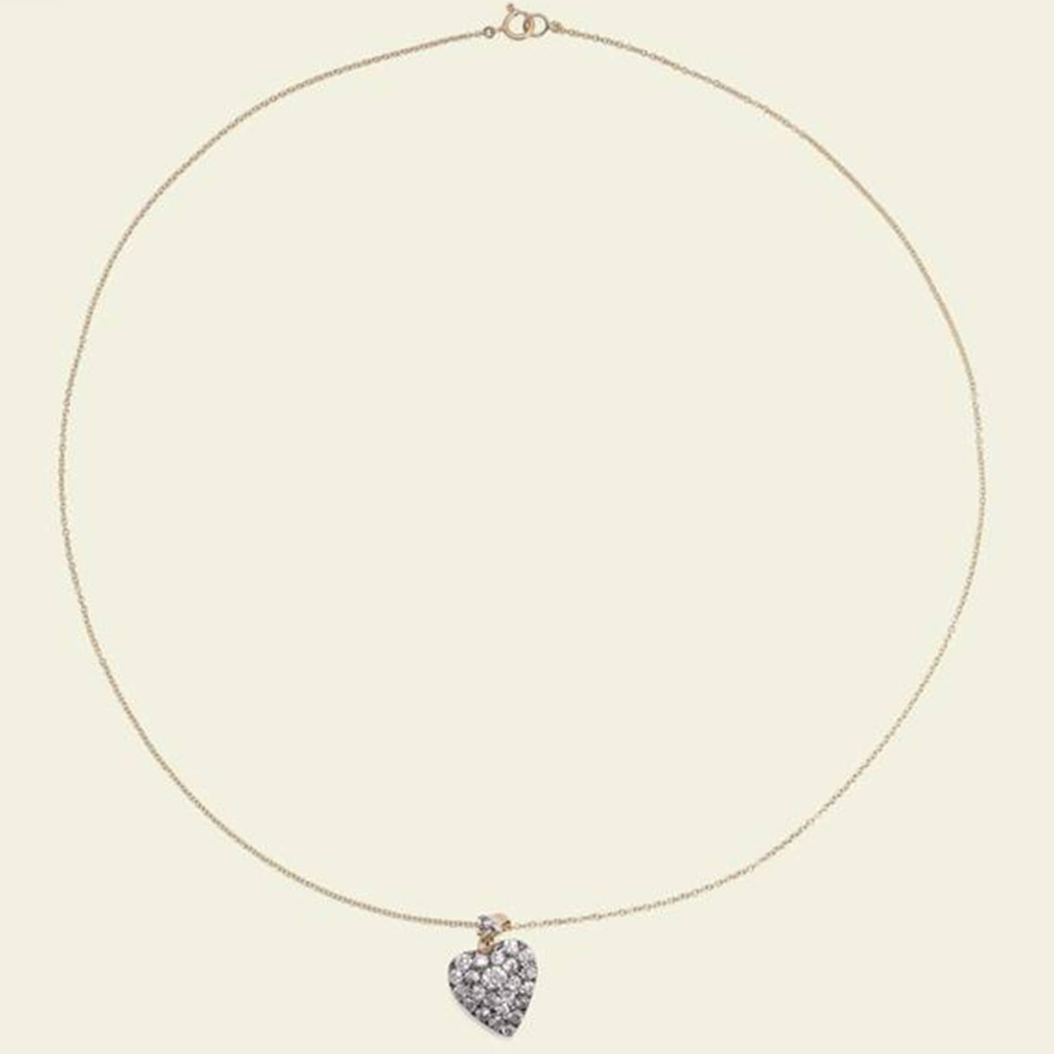 This exquisite love token dates to the late 1800s. The heart-shaped pendant is fashioned in silver atop 14k yellow gold and set with 25 bright old mine cut diamonds totaling 2.06ctw. Hangs from a new 14k gold 18