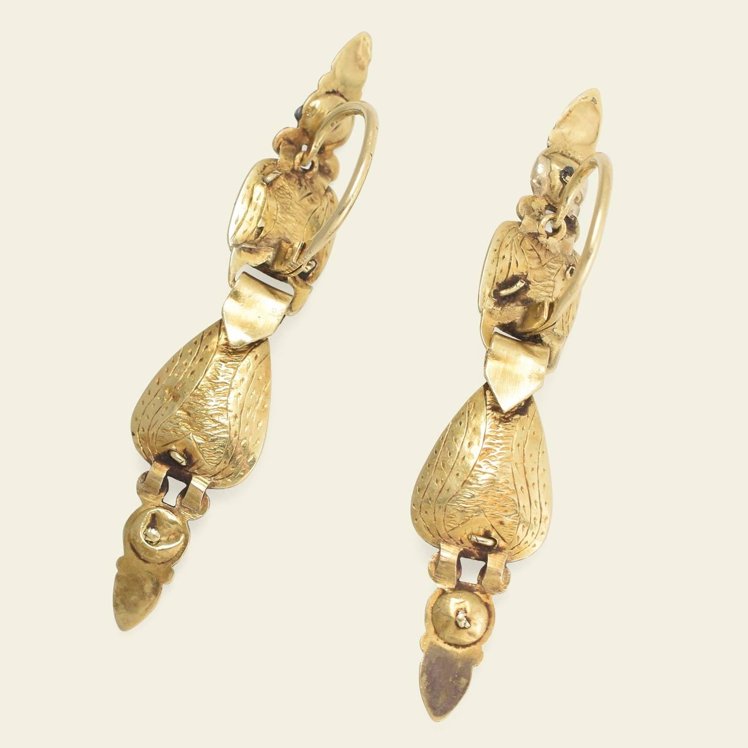 These Iberian earrings date to the late 18th century. Fashioned in 14k gold, these earrings are more minimal in style than much of the jewelry produced in the region during the late 1700s. The drops have a hollow construction, making them relatively