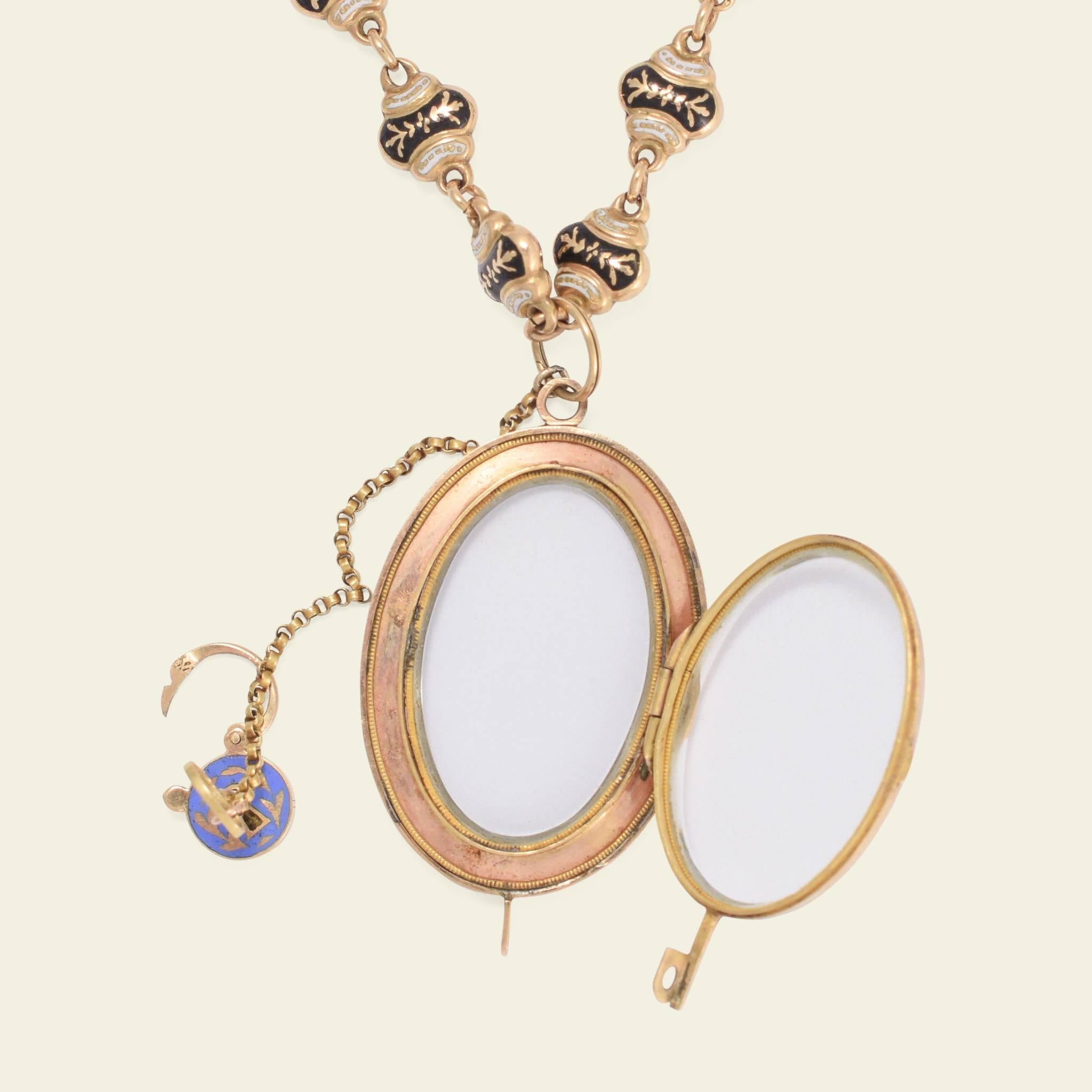 This phenomenal Swiss enamel locket necklace is fashioned 18k gold and dates to the mid 19th century. Each hollow link of the chain is beautifully enameled in blue and black with a lovely decorative clasp stamped with French import marks. The locket