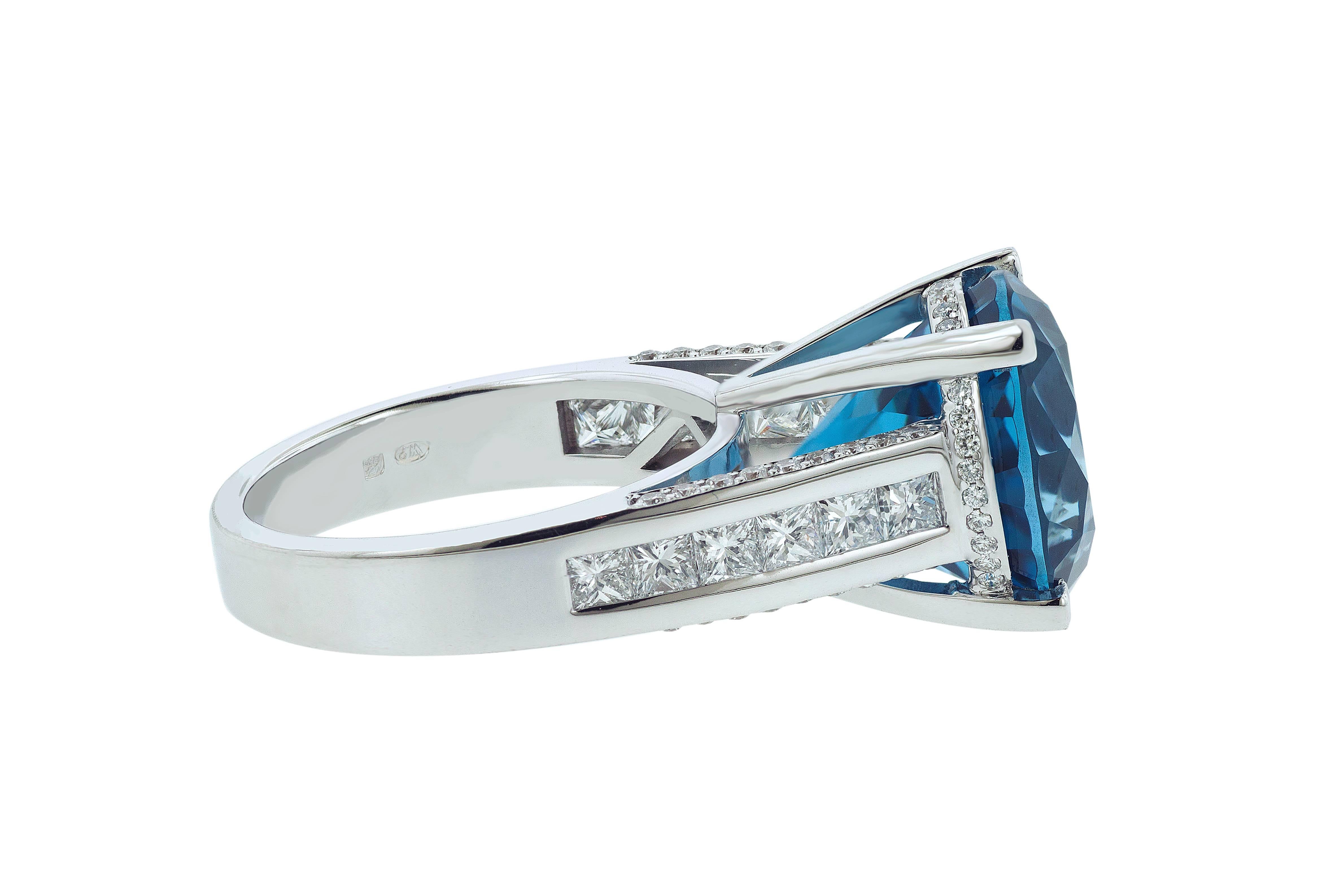 Beautiful and brand new one-of-a-kind London Blue Topaz cocktail ring. Band set in 18 karat white gold with 12 princess cut and pave natural white diamonds. This custom made ring, with perfect setting, is specially designed to fully meet the unique