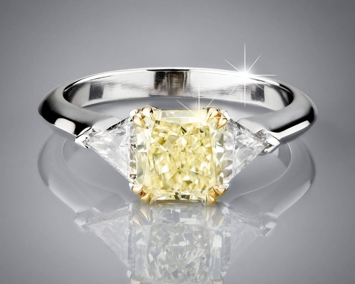 A stunning brand new natural diamond three stone ring in bi-color by Tears Undressed. The ring is set with a 1.45ct fancy yellow radiant cut diamond. Two 0.21ct trilliant cut white diamonds accentuate the central diamond, perfect matched in colour.