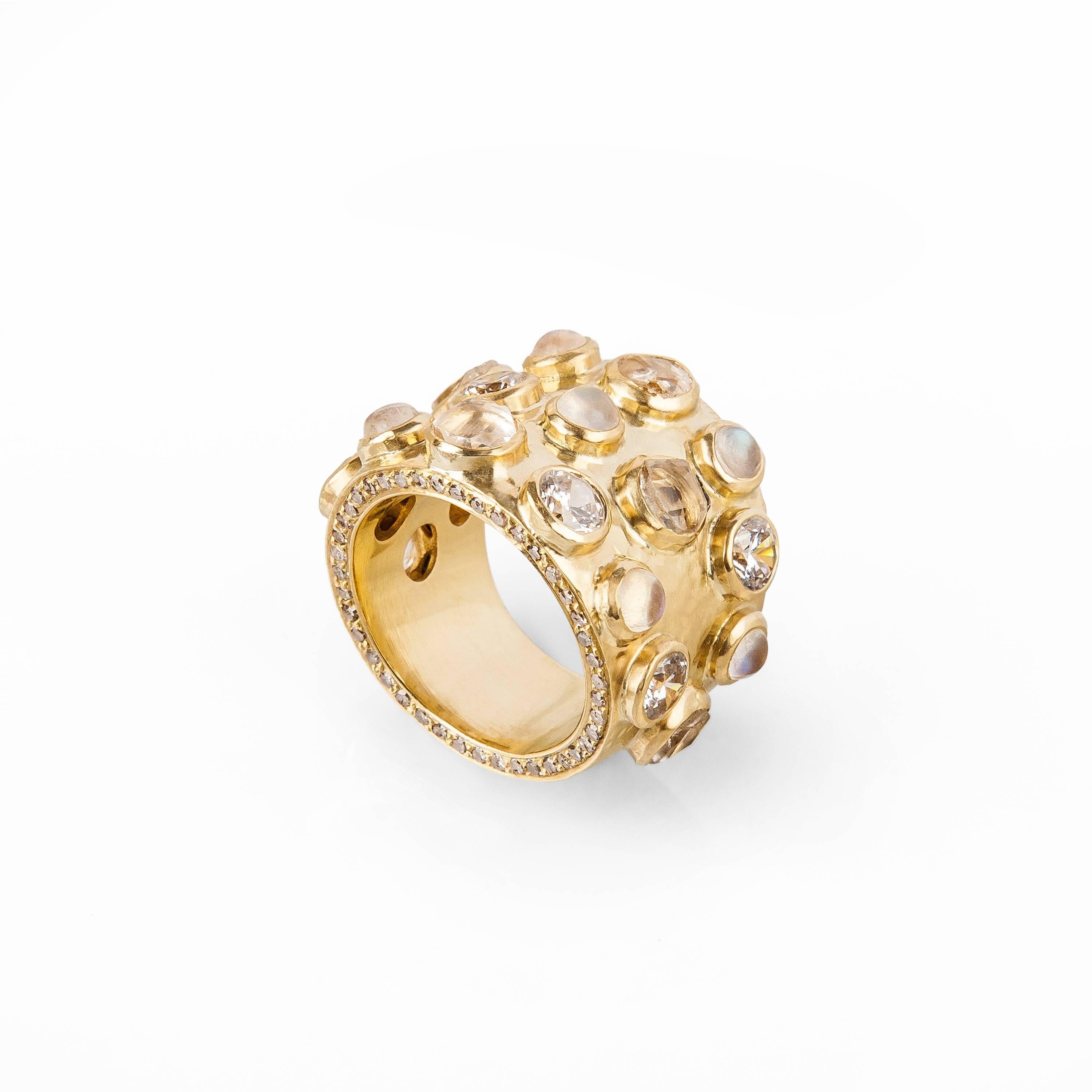 18 Karat solid hand beaten gold. Pave full cut diamonds circle the two outside edges of the ring. On the face of the ring are rose cut white sapphires and cabochon rainbow moonstones. 

Bespoke Options; The ring can be made in Rose Gold. The