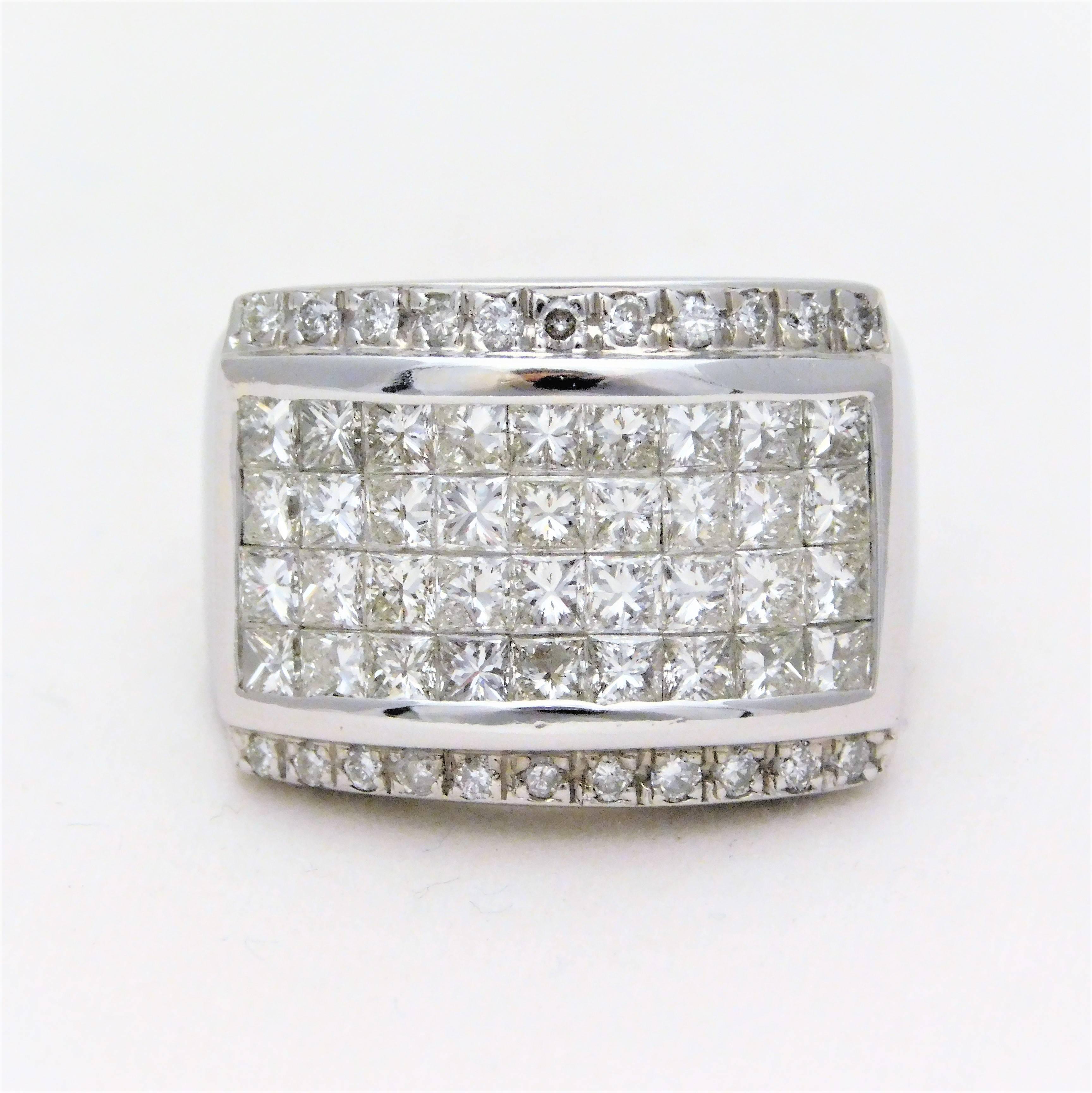 Circa 1990.  From a Southern Gentleman’s Estate.  This prestigious ring is crafted in solid 14k white gold.  It is masterfully jeweled with 54 bright and sparkling princess cut diamonds in an invisible setting.  Flanking the invisible set diamonds