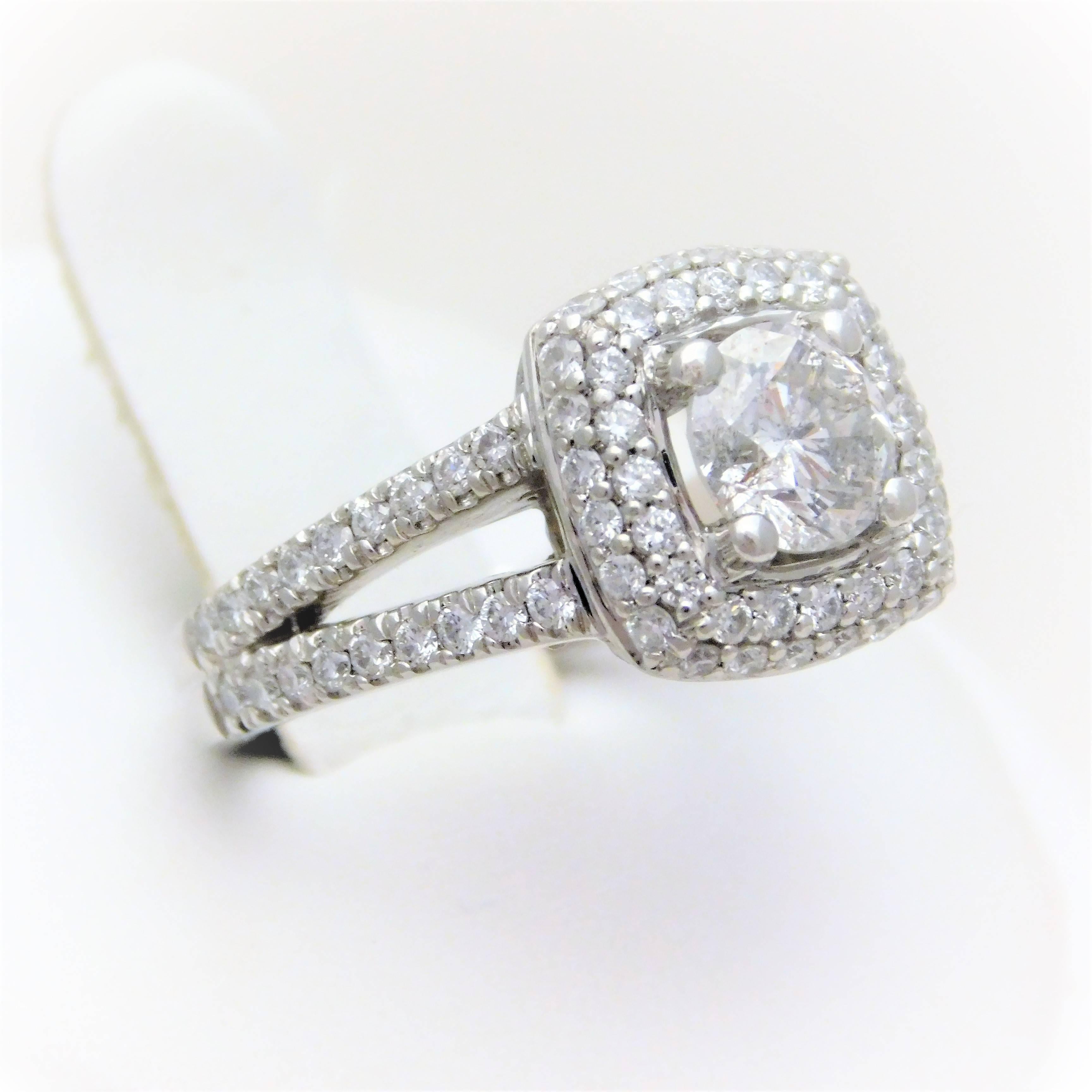 From a Southern Estate.  This absolutely breathtaking custom engagement ring has been crafted in solid platinum.  It has been masterfully jeweled with a 0.98ct/100 round brilliant-cut natural diamond as its magnificent center stone.  This gorgeous