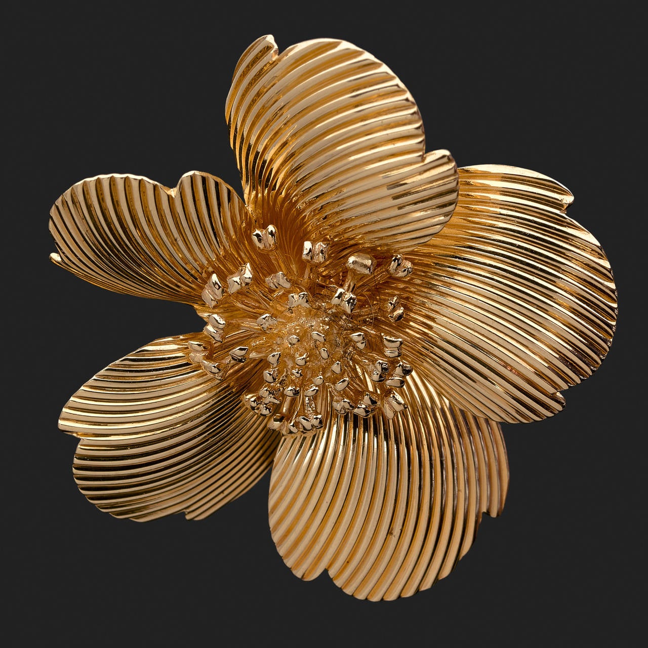 A 14 k gold brooch stylising a flower.