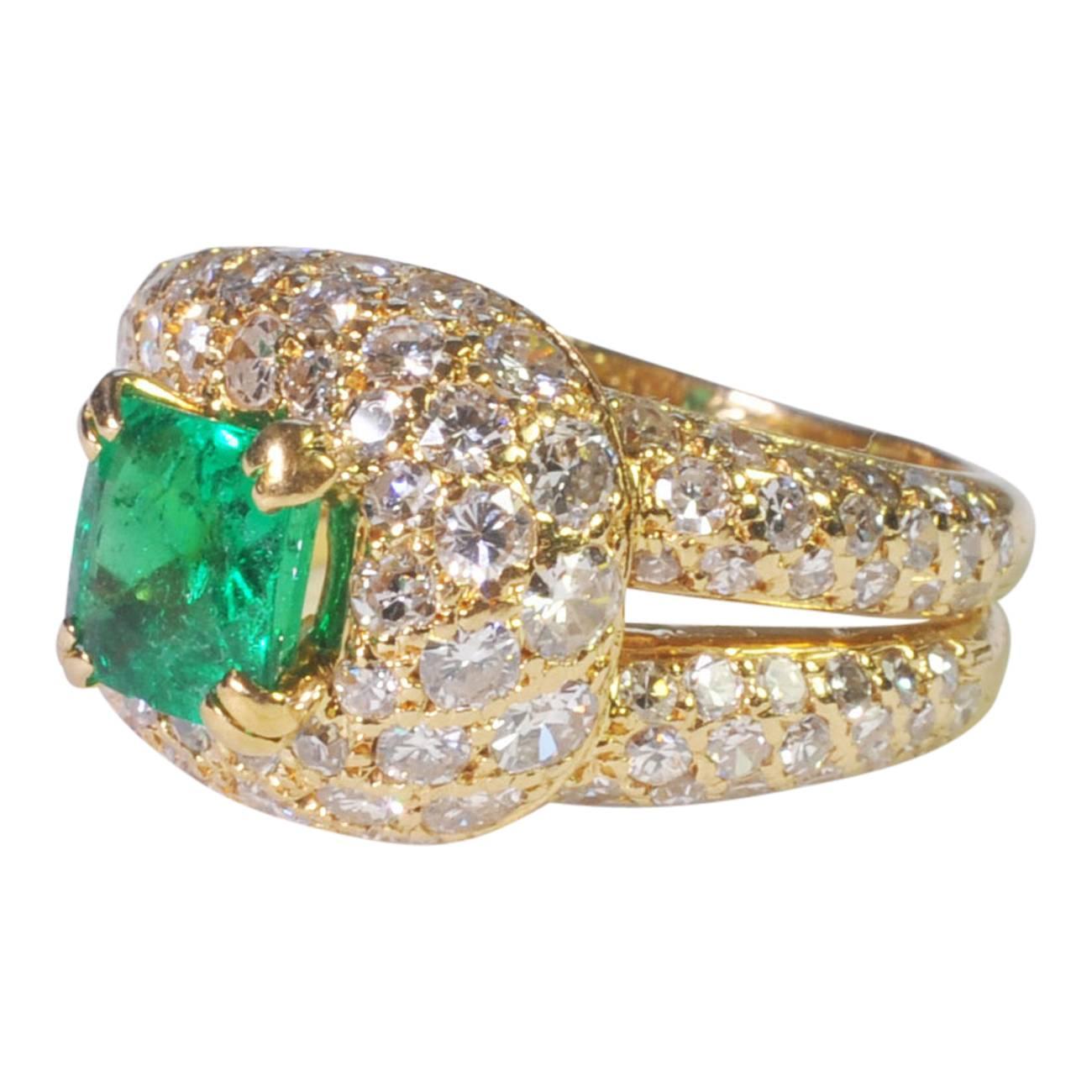Sparkling emerald and diamond ring by Boucheron; the ring is formed of a double gold band pavé set with 8-cut diamonds which loop round a vibrant green/blue emerald.  The emerald weighs 1.04ct, the brilliant cut diamonds weight 2ct (approx).  Signed