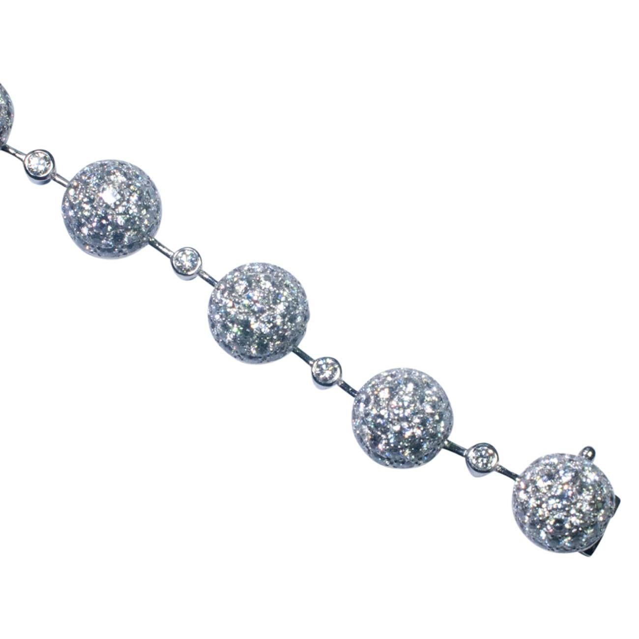 The bracelet is formed of 12 brilliant cut, pavé set diamond spheres linked on a knife blade, with a bezel set, brilliant cut diamond between each sphere.  Total diamond weight, 8cts.  Length 19cms, stamped 750 and signed Chatila.  This family owned