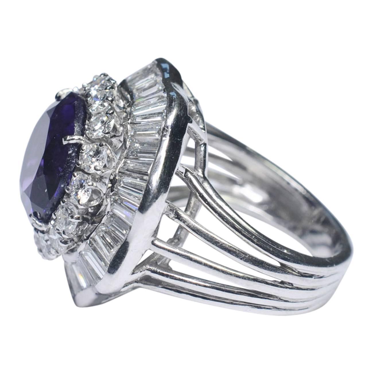 Big, bold and dramatic amethyst and diamond cocktail ring set with a deep purple amethyst weighing 5.22ct.   The stone is surrounded by a double halo of brilliant and baguette cut diamonds in a wavy ballerina design and weighing 4.50ct.  The mount