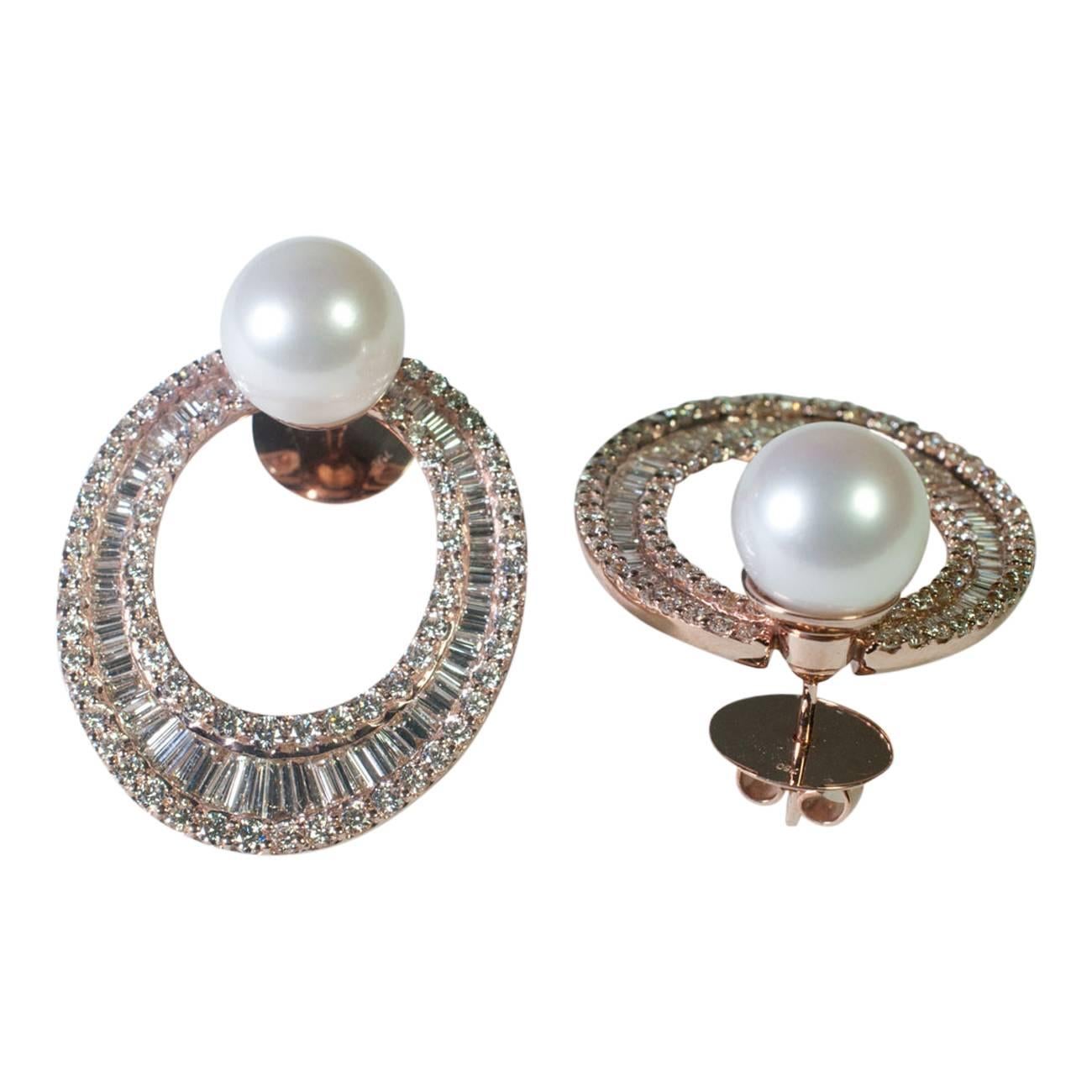 Big, bold and dramatic hooped earrings set with 9 cts of brilliant and graduated  baguette diamonds forming a large hoop with a 10mm white South Sea pearl sitting at the top.  They are mounted in luxurious pink gold with posts and secured by extra