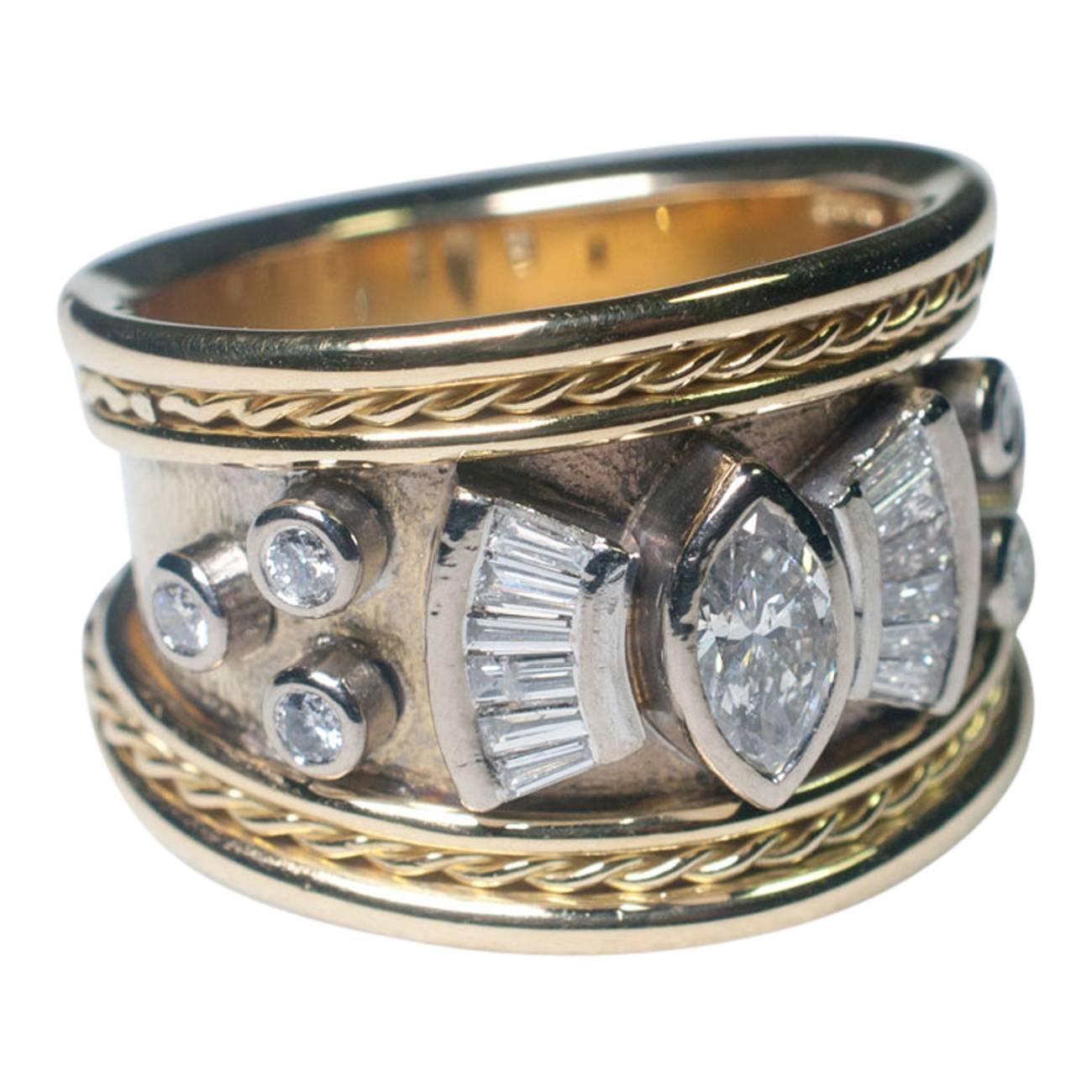 Diamond and gold ring by Stephen Webster in the Etruscan revival style.  It is  set with a central marquise diamond weighing 0.35ct with graduated baguette diamonds fanning out from each side and a further 6 round brilliant cut diamonds, all