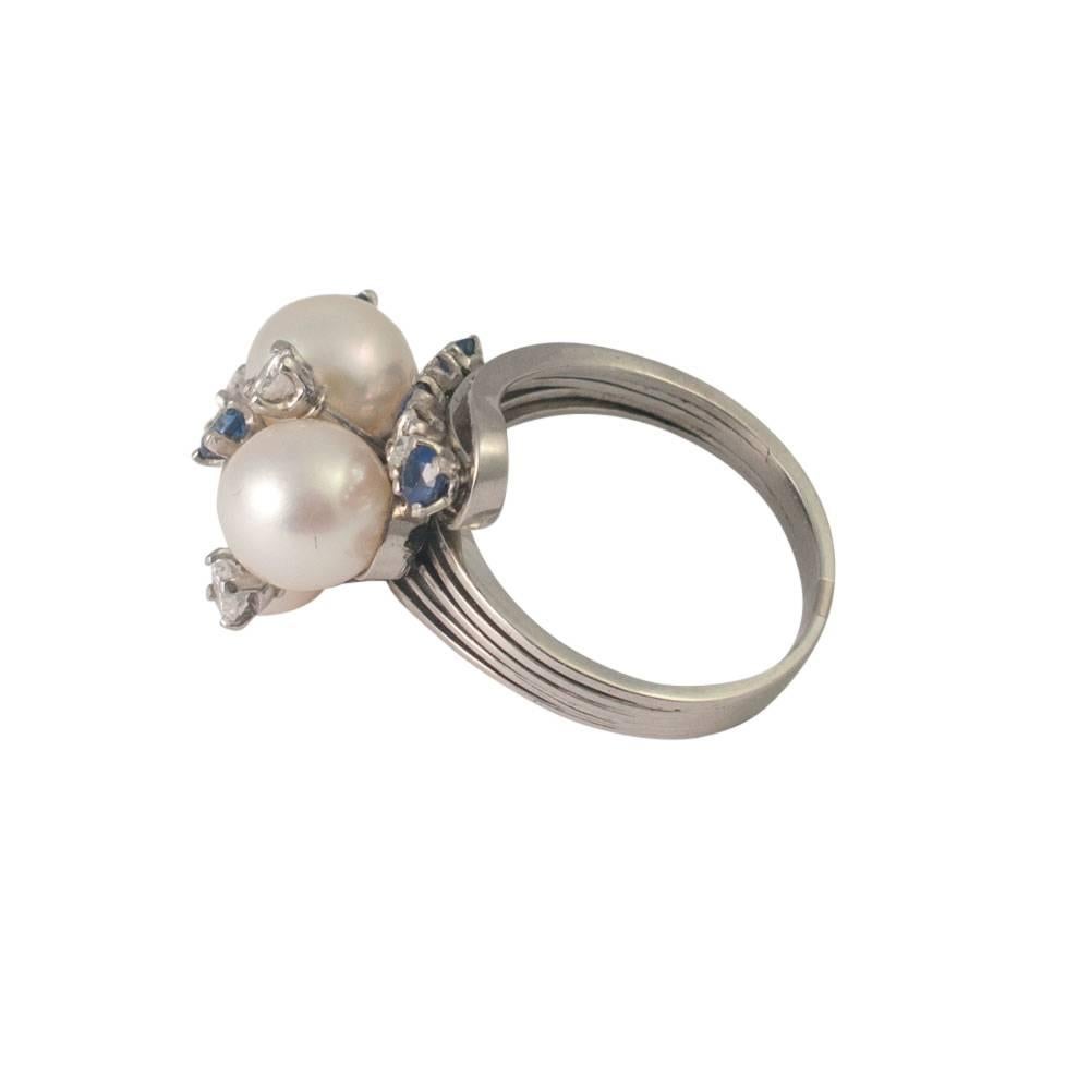 Unusual and stylish mid-century modern, cultured pearl, sapphire and diamond cocktail ring; the ring can be worn both ways round and is formed of a band of sapphires and diamonds attached to a cluster of 4 cultured pearls, sapphires and diamonds. 