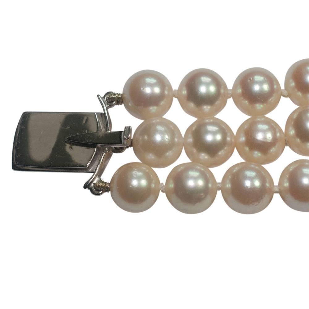 Three row cultured pearl and diamond bracelet.  The lustrous creamy white pearls measure 6.5mm - 7mm and are linked by 2 18ct white gold bars.  the clasp is set with diamond and sapphire flowers with the diamonds totalling 1.75ct.  Maker's mark W