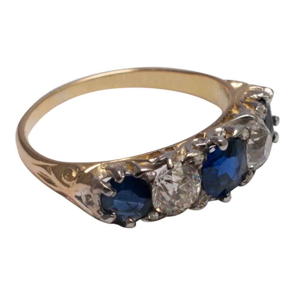 Beautiful Victorian band ring set with three royal blue sapphires and two Old European cut diamonds which weigh 1.10ct.  The ring has tiny rose cut diamond spacers in between the stones.  Weight 3.4gms; tested as 18ct gold.  Finger size M (UK), 6.5
