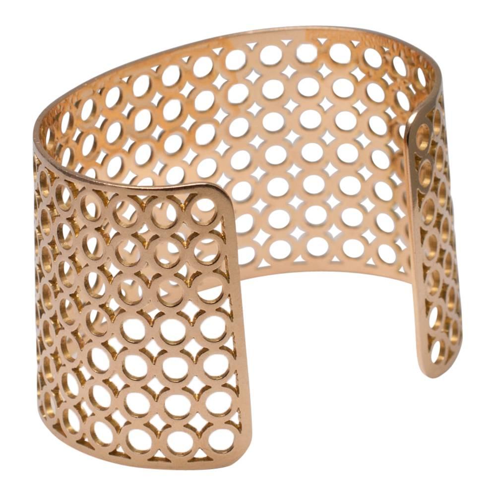 Stylish 18ct gold Theo Fennell cuff bangle; the gold openwork is in a retro circles design reminiscent of the 1960s.  Weight 51.5gms; measuring 7cms in diameter so it will fit most wrists; depth 4cms.  Hallmarked 18ct gold and signed Fennell.
