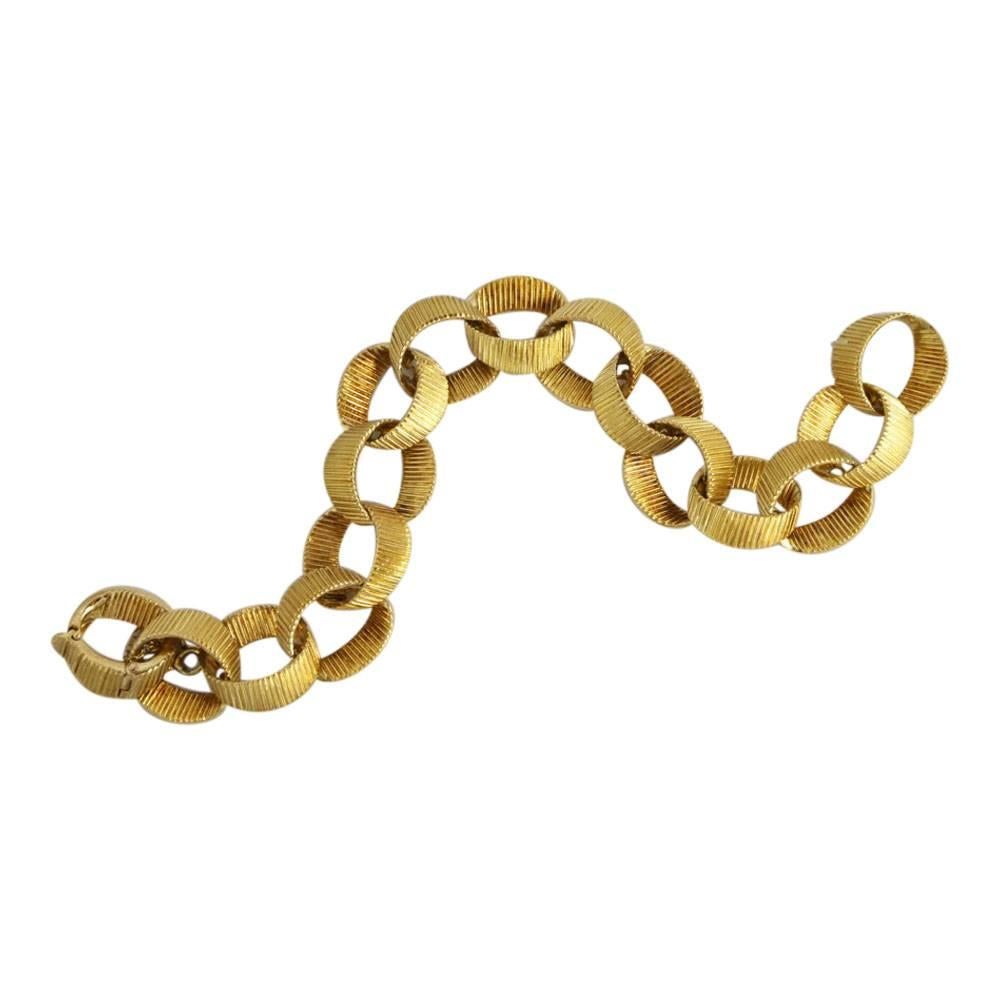 Textured 18ct gold link bracelet by Chaumet, Paris;  this is formed of semi flattened interlinked circles with the clasp forming one of the circles.  There is also a security chain attached.  Signed Chaumet, Paris and stamped with the French state