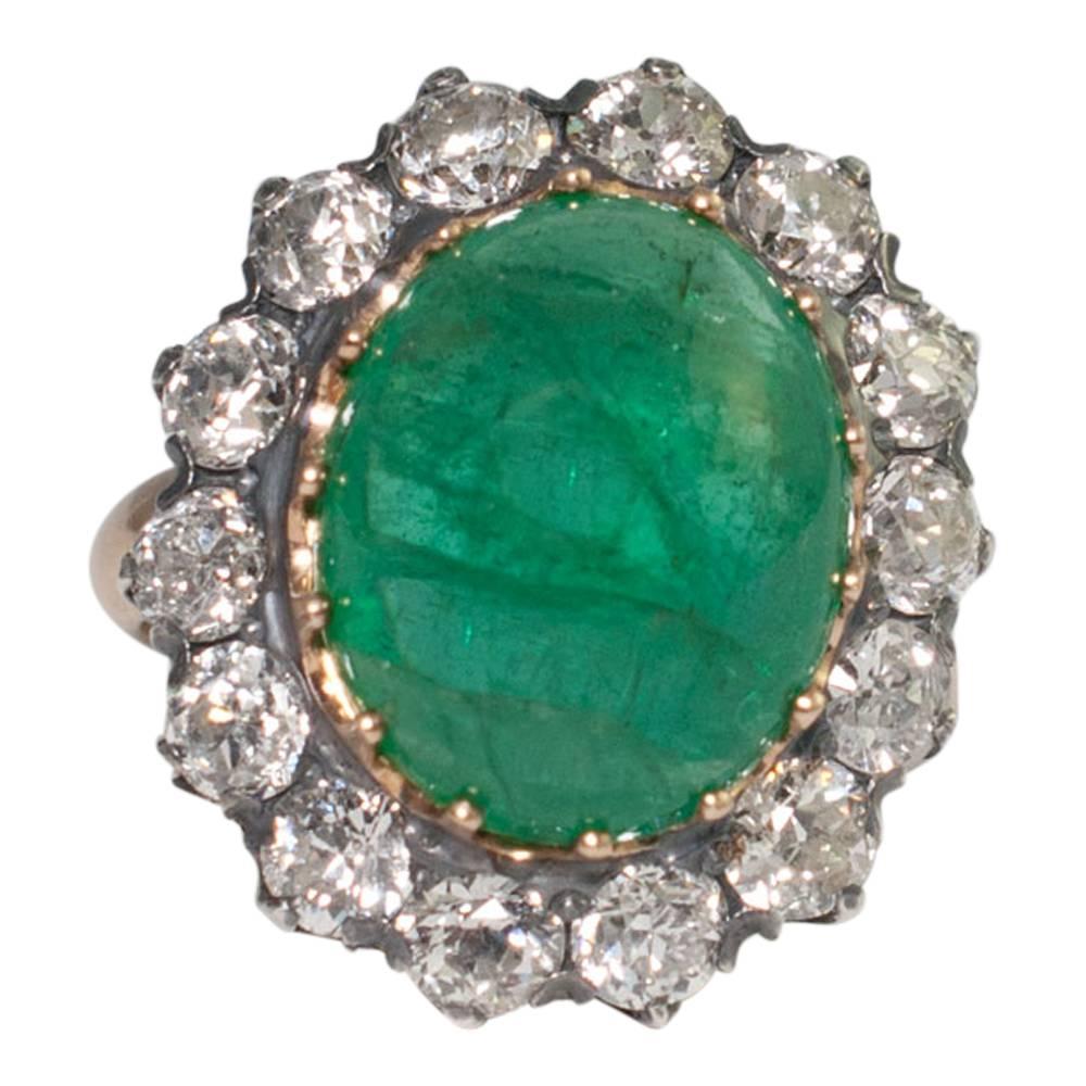 Large Victorian emerald and diamond ring set with a 10ct cabochon emerald surrounded by 14 Old European cut diamonds weighing 2.80ct. Weight 9.3gms.  The diamond are set in silver as was customary at the time and the mount tests as 18ct gold.  