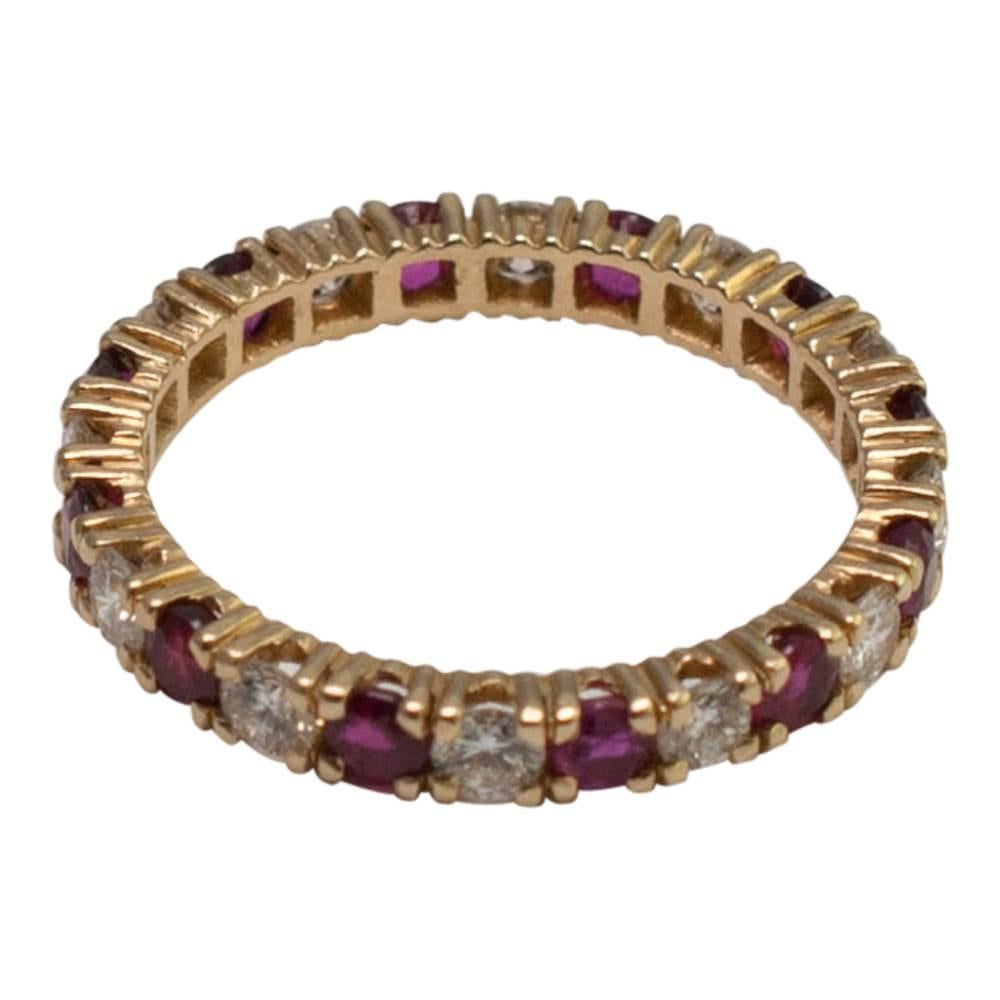 Ruby and diamond full eternity ring; the deep red rubies weigh 0.72ct, the brilliant cut diamonds weigh 0.72ct.  Set in 18ct yellow gold, stamped 750; weight 2.2gms.  Finger size L1/2 (UK),  6.25 (US), 52 (EU).
A video of this ring is available.