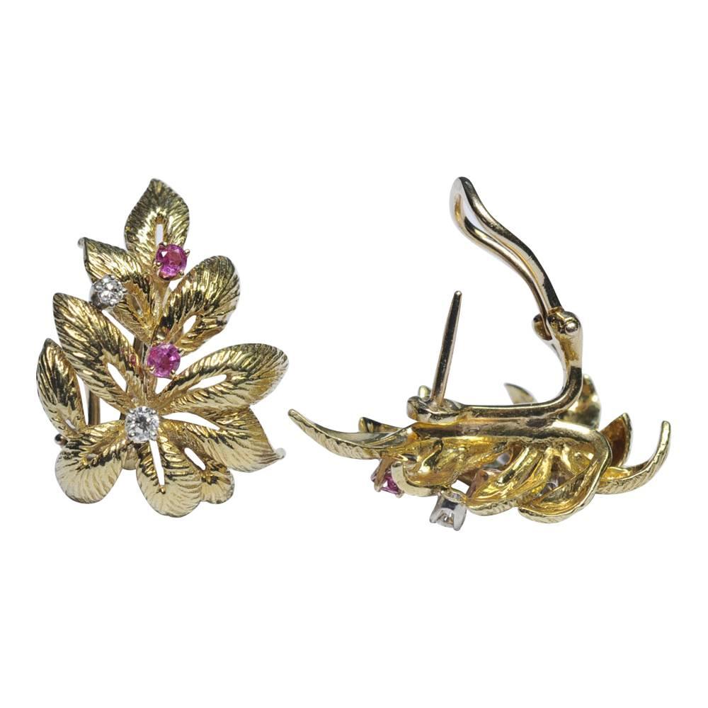 Stylish gold leaf design earrings set with rubies and diamonds; the leaves are intricately carved and each earring has two rubies and two brilliant cut diamonds, and mounted with a clip and post for added security.  Weight 15.5gms; measurements 3cms