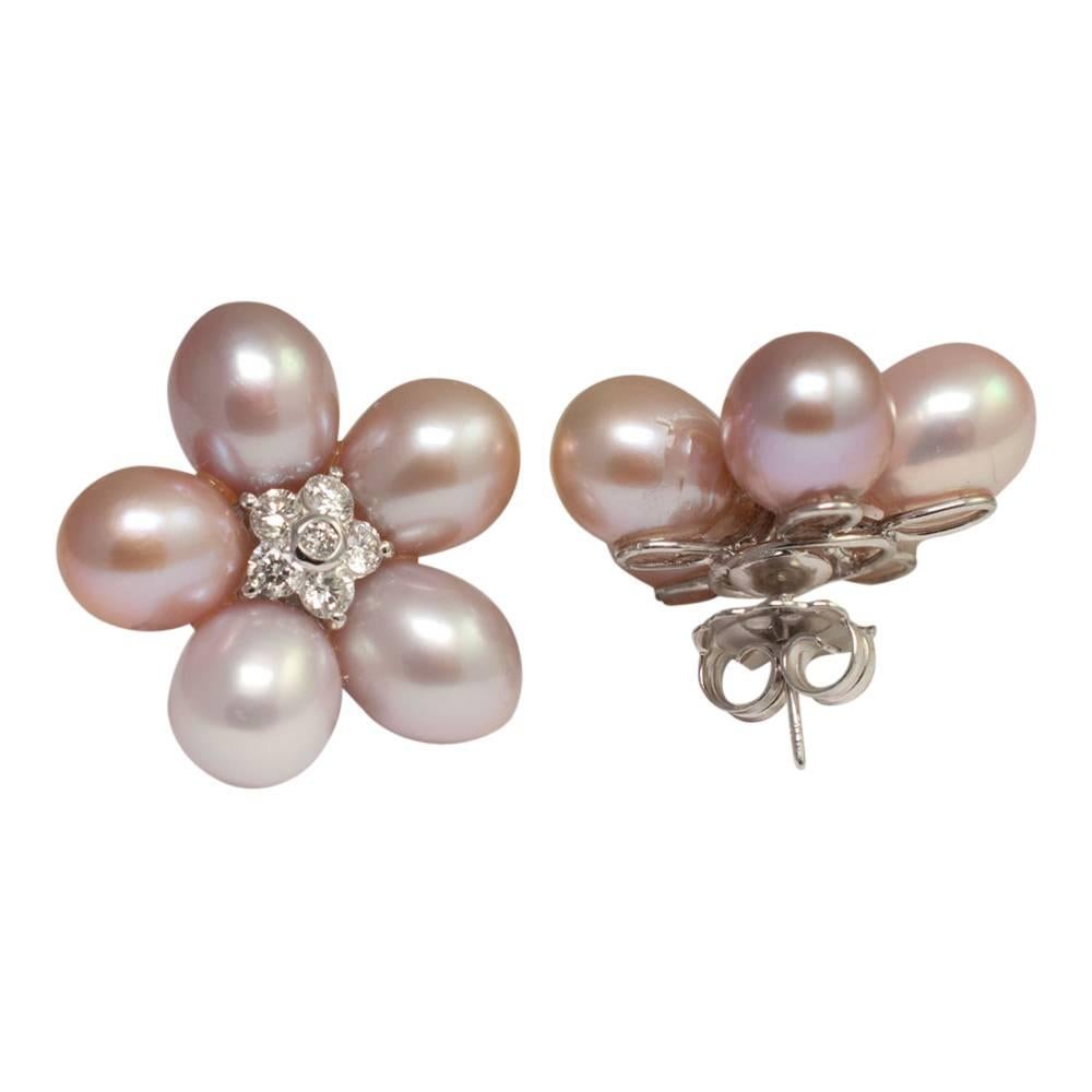 Big, bold and dramatic South Sea pearl and diamond flower earrings; the natural coloured oval pearls each measure 9mm and form a flower petal surround.  In the centre there is a cluster of brilliant cut diamonds weighing a total of 1.10ct.  Weight