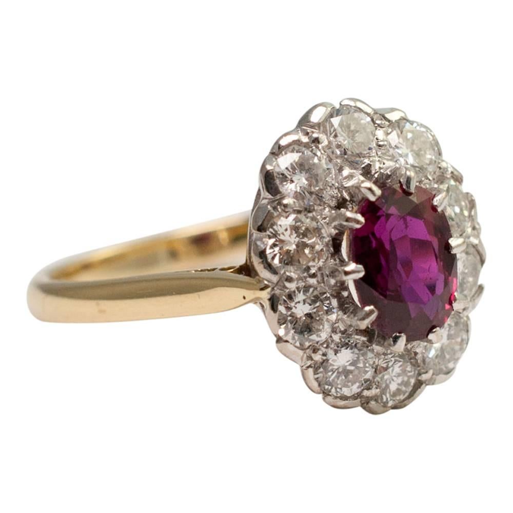 Vintage ruby and diamond halo ring; the oval, mixed cut  ruby weighs 0.85ct and is surrounded by a halo of brilliant cut diamonds weighing 1ct.  This pretty ring would make a perfect engagement or ruby wedding anniversary ring for the girl who loves