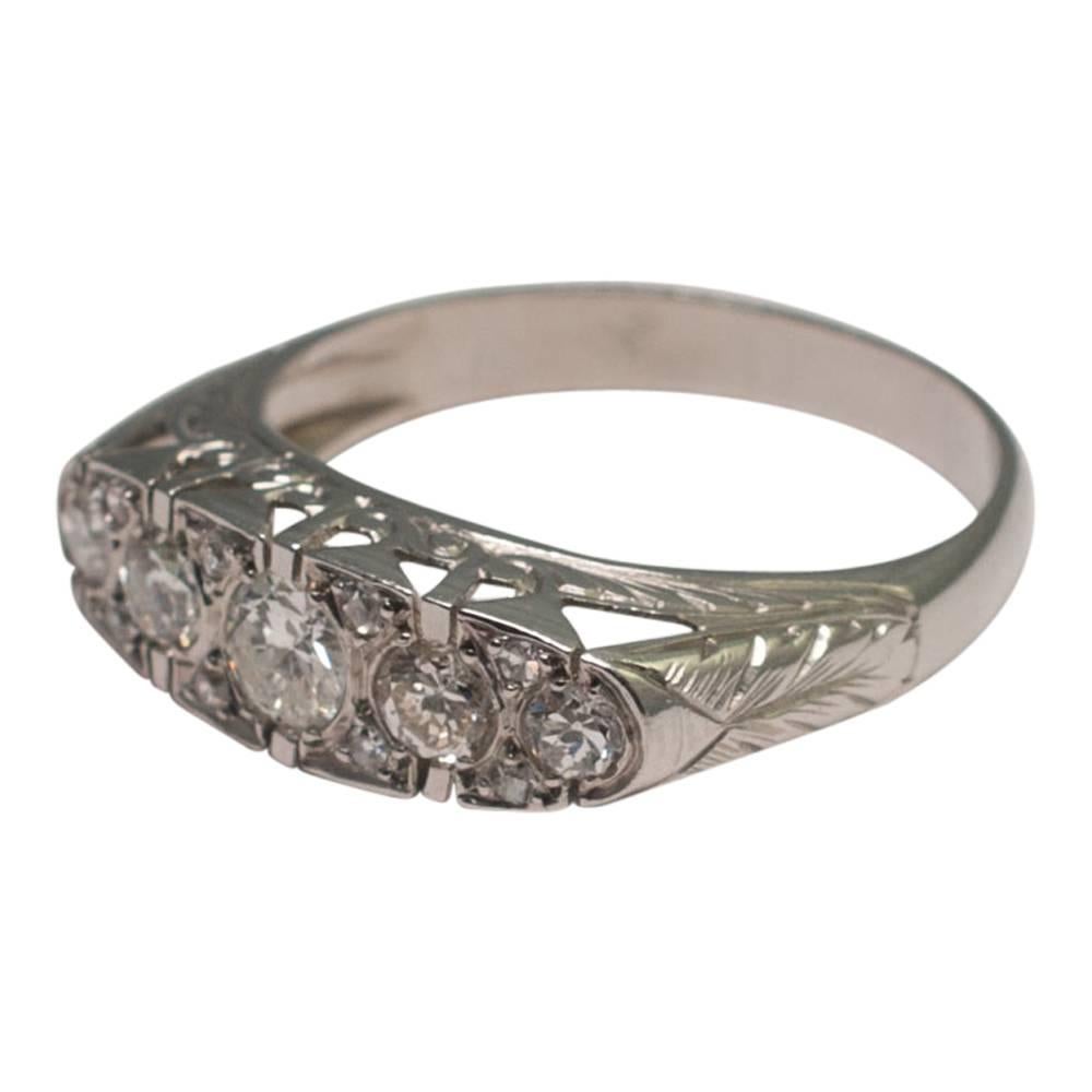 1930s French diamond ring set in platinum.  It is set with five main, graduated diamonds totalling 1ct; the main central stone is Transitional cut and is flanked by 4 Old European cut diamonds.  There are 8-cut diamond accents above and below the