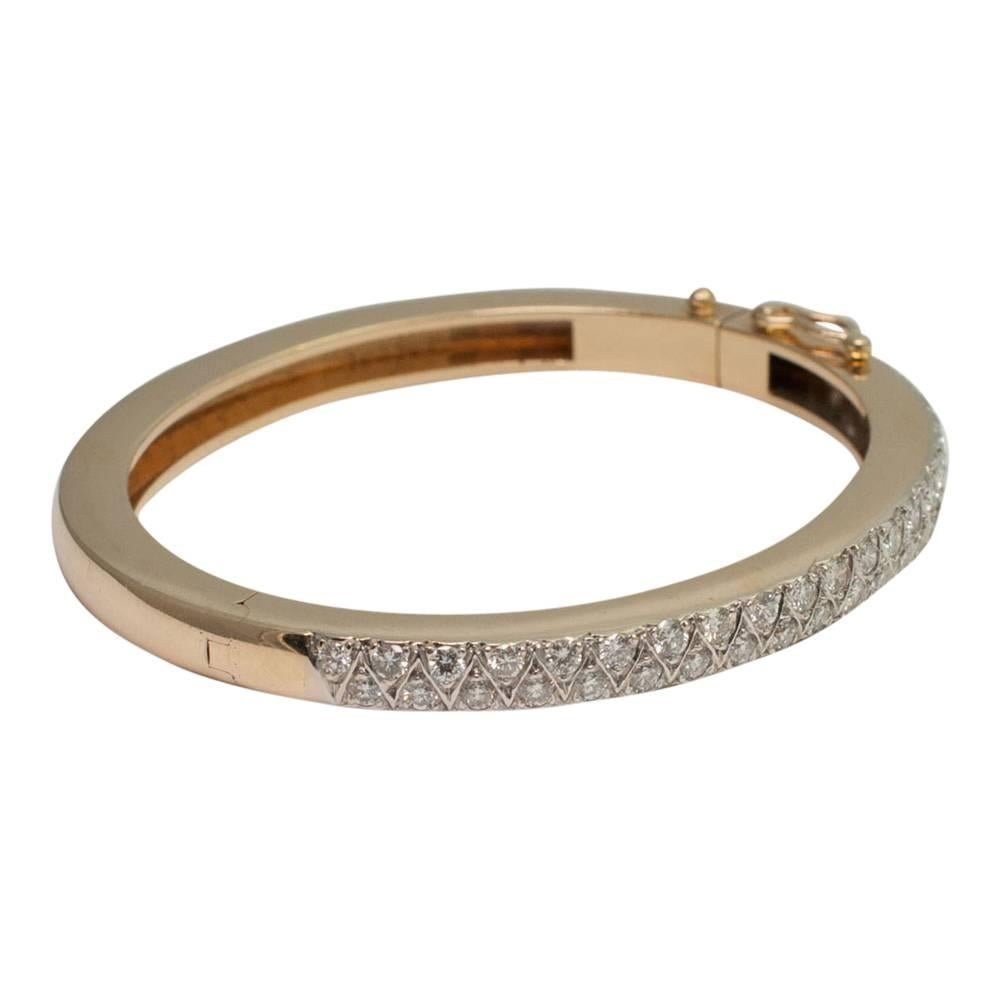 Diamond set half hoop, 14ct gold bangle; the two rows of brilliant cut diamonds weigh 2.88cts; The bangle opens on a side hinge and has a figure-of-eight lock.  Weight 32.6gms. Depth 5mm (1/4");  width 5.5mm (3/8") Internal measurement