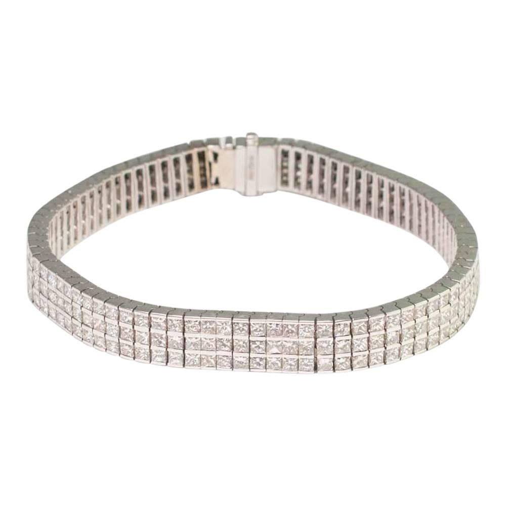 Beautiful triple row diamond set line bracelet which consists of 84 articulated rectangular panels, each channel set with three princess cut diamonds measuring 2.1mm x 2mm.  The bracelet measures 0.82cm wide x 19cm long  and fastens with an integral