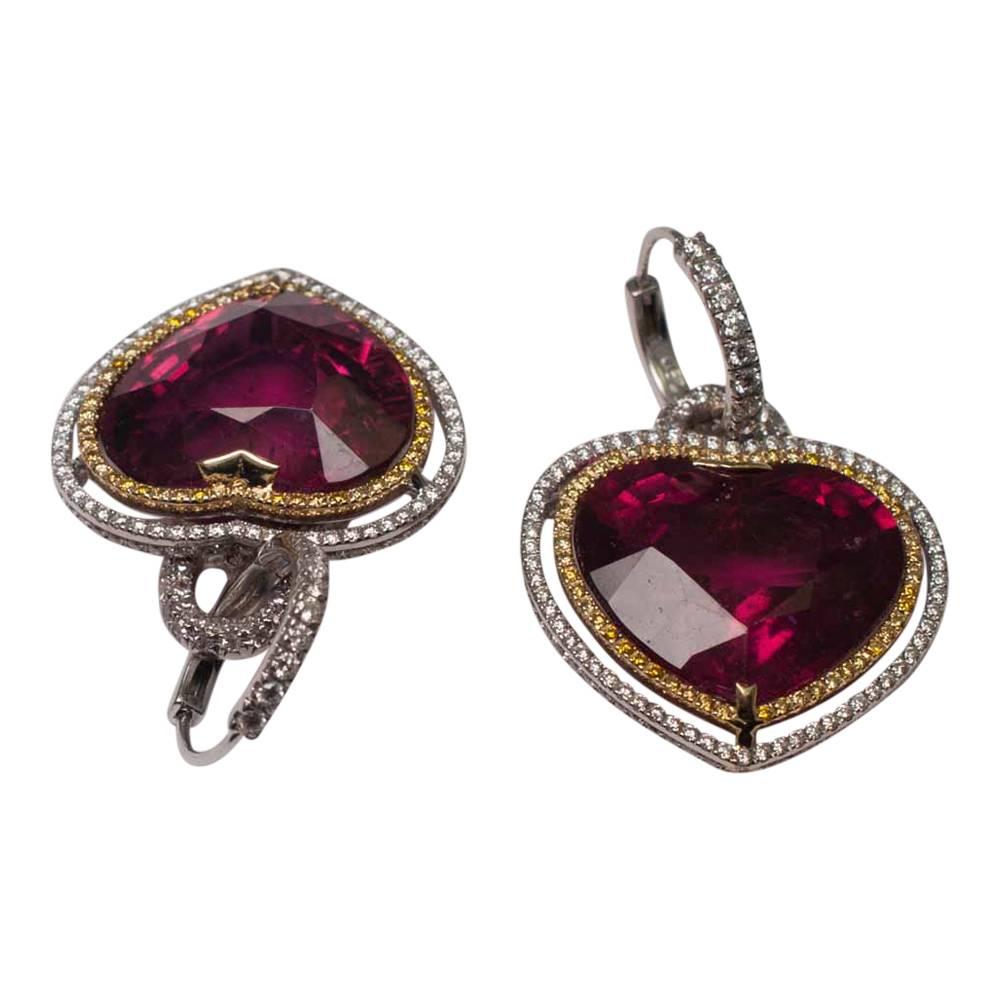 Huge, dramatic raspberry heart shaped rubellite day and night earrings;  the deep pink rubellites each weigh 28ct and are suspended from diamond set hoops which can be worn separately.   For evening wear the rubellites can be attached; each one is