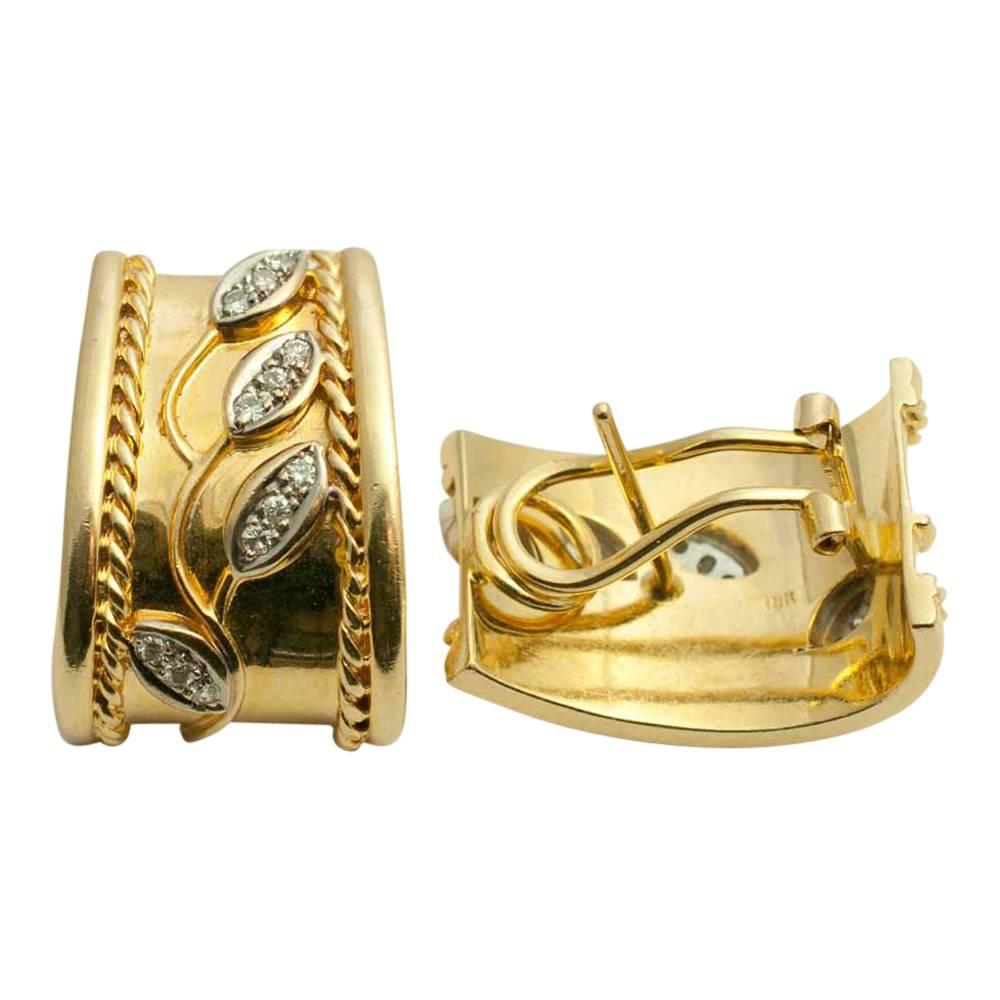 Stylish earrings in lustrous 18ct gold with a diamond set floral motif and a rope twist pattern.  The top tapers out to a wider base; length 2cm x width at base 1.50cm. Weight 17.4gms.  Mounted with a spring clip and post for added security.