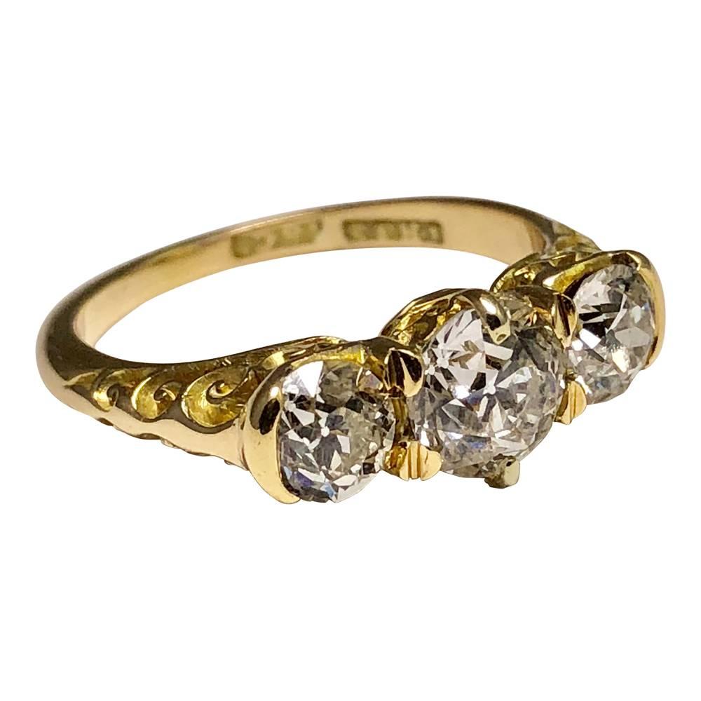 Late Victorian diamond trilogy ring set with 3 sparkling Old European cut diamonds;  the centre stone weighs 1.07ct and is flanked by two diamonds each weighing 0.50ct; total diamond weight 2.07ct.  The stones are set into an 18ct yellow gold