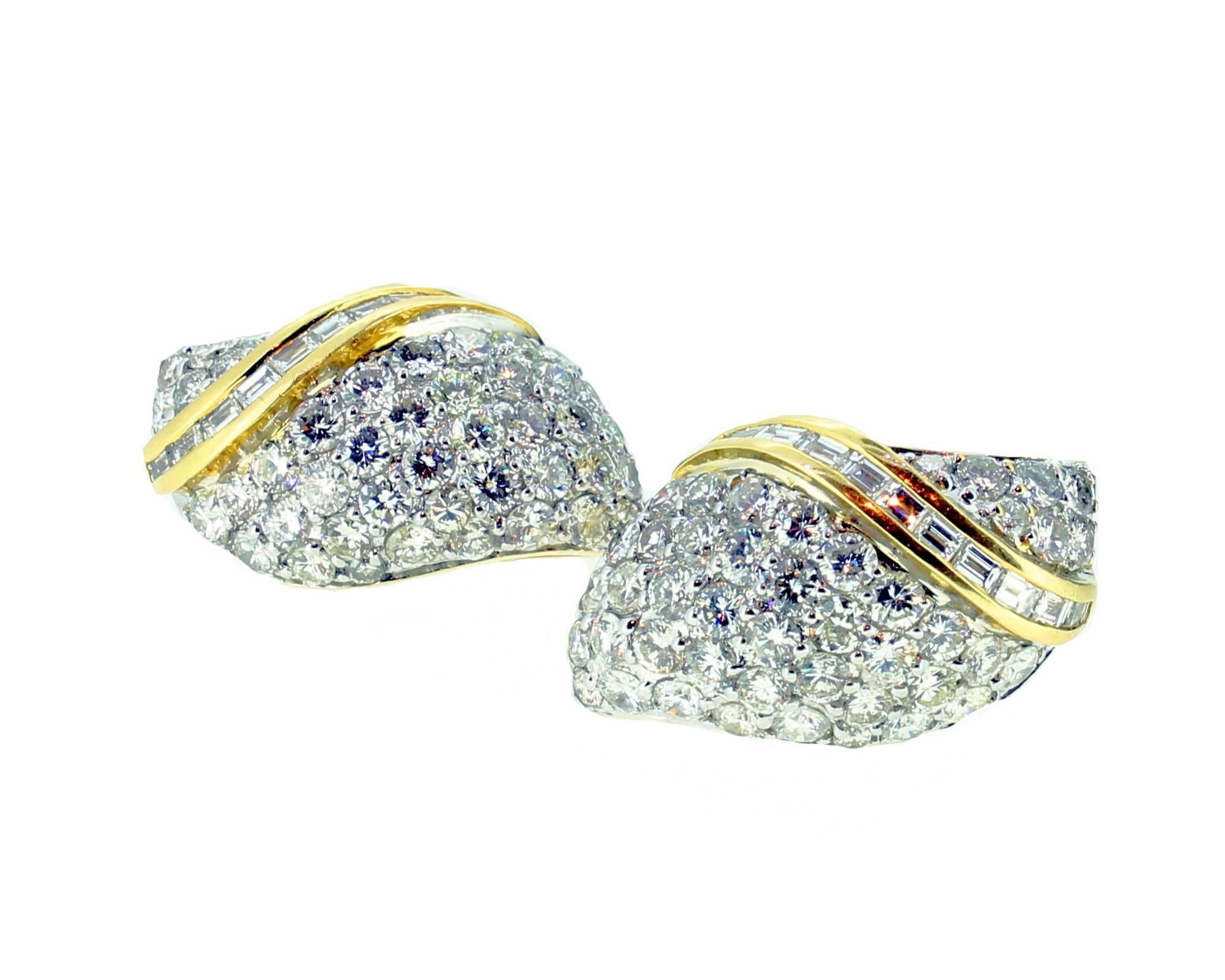 Marcus & Co Pave set diamond earclips mounted in 18ct white and yellow gold. American. Circa 1980. The central pave set white gold diamond sections split by a scrolling 18ct yellow gold baguatte cut diamond section. Marked 750. With